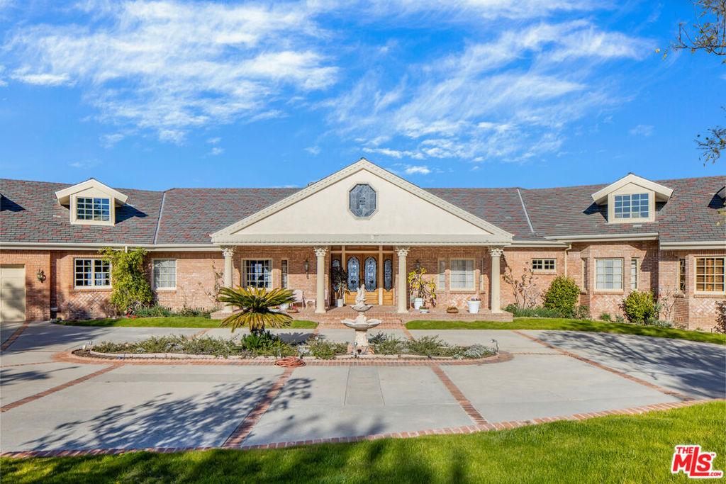 Sited discreetly beyond a gated entry, this 8-bed, 12-bath stately treasure of a home offers a rare single-story paradise designed with an eye for the utmost in tranquility and sophistication throughout. Upon entering, you are greeted by a formal living room with an elegant fireplace showcasing a detailed custom mantel. An elegant hall leads you directly into an impressive sun-soaked family room with vaulted ceilings accompanied by a custom wooden wet bar. You will find an oversized formal dining room with a crystal chandelier and windows that infuse an abundance of natural light. A gourmet kitchen with a center island is highlighted by professional-grade appliances and a breakfast nook with french doors that open to the outdoor oasis featuring, landscaped gardens, a pool/spa with breathtaking views overlooking the entire valley, tennis court, and a 4,151 sqft detached guest house. Conveniently close to top-rated schools, world-class dining and entertainment. This is the perfect home for the California lifestyle.