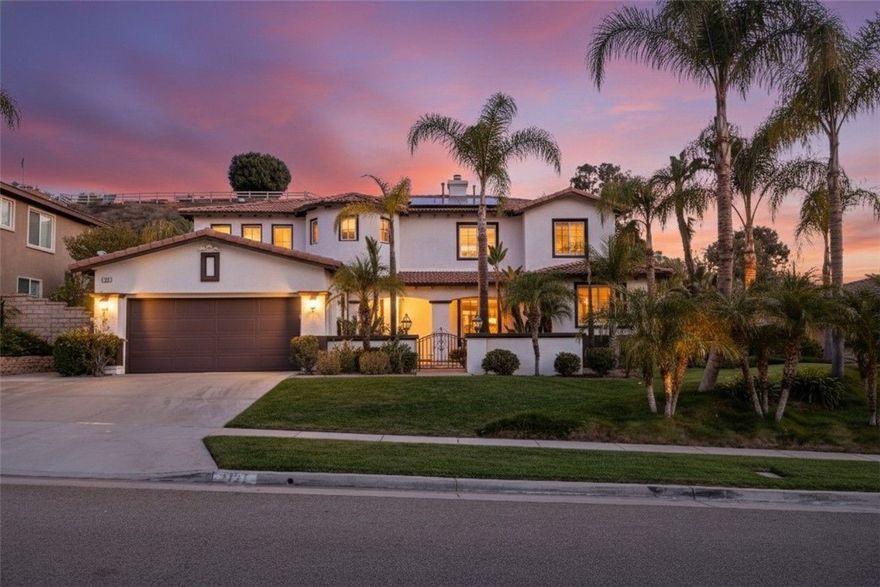 Beautifully upgraded home located in the highly desirable Eagle Glen community. This spacious residence features a large entry living room with vaulted ceilings and abundant natural light. The formal dining room is conveniently located off the kitchen, perfect for entertaining. The chef’s kitchen offers an oversized center island, ample counter space, and opens to the family room complete with a cozy fireplace. Downstairs includes a bedroom and full bathroom, oversized office, and laundry room for added convenience. Upstairs features three guest bedrooms, including one with an en-suite bathroom, plus an additional guest bath. The primary suite is light and bright, offering a luxurious en-suite bathroom with dual sinks, walk-in shower, center soaking tub, and walk-in closet. Enjoy resort-style living in the private backyard oasis, featuring a rock pool with waterfall, grotto-style spa, and palapa-covered patio—perfect for entertaining or relaxing. Additional highlights include a solar system, two-car garage, and a prime location near the 15 freeway, Fastrak entrance, schools, shopping, and dining.