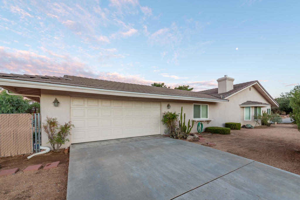 Well maintained would be an understatement - this beautiful corner-lot home has been meticulously curated and thoughtfully upgraded, offering nearly 2,500 sq. ft. of open-concept living space with 3 bedrooms and 2 bathrooms. Over the years, the property has seen numerous upgrades including a new roof, Milgard windows, furnace, AC condenser, carpets, interior/exterior paint, fireplace, plantation shutters, and a fully permitted enclosed patio. Every detail reflects pride of ownership and a commitment to quality. The floor plan offers seamless indoor/outdoor flow. A spacious great room leads to the enclosed patio, while the kitchen features granite countertops, stainless steel appliances, bar seating, and abundant cabinetry. Additional highlights include a dedicated dining room, living room, laundry room, and flexible bedrooms - one currently designed as a home office. The backyard evokes desert sanctuary vibes and pure relaxation, with sandstone pavers weaving through a beautiful desert garden anchored by a striking Mesquite tree and a mature Joshua Tree as the focal points. Multiple patios, RV parking with septic and electrical hookups, a 2-car garage, and extensive driveway space provide both connivence and functionality.