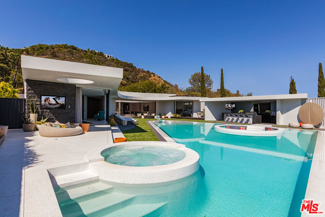 Slip into this mid-century modern oasis, the pinnacle of Beverly Hills style, 60s sexiness and 2017 smart living. Sinatra's flair with Bond's Technology. Tucked into one of Trousdale's most private streets, no expense was spared in pulling this 60s socialite dream home into the 21st century. From the sweeping roofline to the flared pool edge, every line is elegant and tantalising, as if sketched by Pininfarina. Meticulously detailed, every inch has been engineered to the slightest degree: from the heated terrazzo floors to the slabs of rare stone. Stir up a martini and set the scene: each detail is just a touch of a finger away via the Savant system. Stroll out to your poolside bar and floating lounge overlooking explosive views of LA. There is no substitute for this lifestyle. Welcome to Trousdale, where legends called home, from Elvis, Sinatra, Dean Martin to Nixon. "Dream as if you'll live forever, live as if you'll die today."