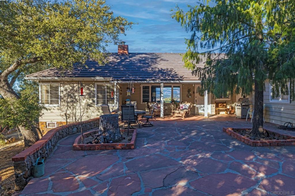 AMAZING VIEWS! Nestled at the top of a scenic hill in Julian's highly sought-after Pine Hills neighborhood, this captivating 1949 home exudes timeless mountain charm and privacy. With only three part-time owners, this remarkable property offers 1.16 acres of serene natural beauty, with old oaks, towering pines, and manzanita. A highlight of the property is the detached guest studio with a deck, and the flagstone courtyard, with its natural stone-lined pathways, providing a tranquil escape for relaxation and outdoor enjoyment. The panoramic views of the Volcan Mountain range will take your breath away. This is an ideal setting for birdwatching and observing the local wildlife, including herds of deer, turkeys, and the occasional fox. The home is in charming original condition, reflecting the thoughtful design of its first owner—an engineer and designer. The classic vintage tile, fixtures, fireplace, and wood floors create a nostalgic allure. The exterior is crafted with hard old-grove redwood siding, known for durability and beauty. The home features zoned area heating and air conditioning mini-splits for efficient performance, two water heaters (including one for the separate studio), and a large Elvira wood-burning insert for cozy warmth on cooler days. This home blends comfort with character. The property includes an attached and detached garage, a carport, and ample parking for guests. The land is cleared and meticulously maintained, ensuring easy access and usability. With a metal-tiled roof and pest-resistant old grove redwood siding.Move in ready!