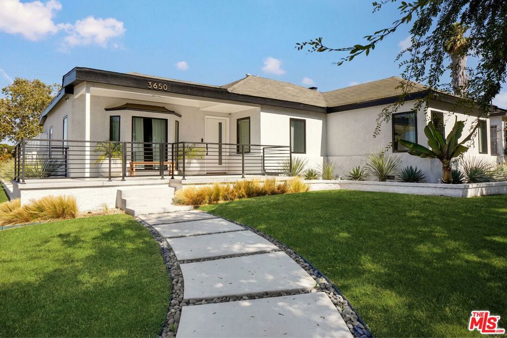 This beautifully remodeled 3-bedroom, 2-bathroom home is nestled in the heart of Crenshaw Manor - a peaceful, tree-lined enclave and one of Los Angeles' hidden gems. Thoughtfully redesigned from top to bottom, this home features stunning designer upgrades throughout, offering a perfectly balanced blend of style and comfort. Natural light streams in through custom Marvin windows and highlights the clean, modern finishes and fixtures. Enjoy an elevated open-concept living area framed by a charming gas fireplace, with seamless flow into a sleek, updated kitchen outfitted with professional-grade appliances, oversized center island and ample cabinetry - ideal for both everyday living and effortless entertaining. The three bedrooms are all generously sized and include a sumptuous primary suite with a beautiful bay window that perfectly frames the tranquil front yard, complete with mature trees and landscaping. Two guest suites share a spa-like bathroom with an oversized walk-in shower, double vanity and custom tile work. Beyond the sliding Fleetwood doors, an expansive backyard offers a true retreat featuring a covered terrace perfect for al fresco dining, lush citrus trees, and wide grassy lawns ideal for play or relaxation. A built-in fire pit creates a cozy spot to gather in the evenings, and a detached two-car garage offers convenient private parking or the potential for an ADU. Set in a quiet, community-focused neighborhood with a charming residential feel, this home offers the rare combination of tranquility and central convenience - minutes from some of the most sought-after restaurants, including Jon and Vinny's, Farmhouse Kitchen and Highly Likely. Don't miss your chance to live in one of LA's best kept secrets.
