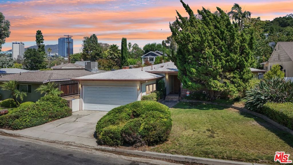 Nestled on a peaceful street just moments from Ventura Blvd, this charming 3-bedroom, 3.5-bathroom Studio City home is filled with warmth, character, and generous living space. A formal entry opens to a sun-drenched living room with a classic fireplace and a layout that flows seamlessly into the kitchen, which features a breakfast area, ample counter space, and open sightlines to the living area, making it ideal for both everyday living and entertaining. Just off the entry is a powder room, and nearby, a dedicated laundry area with a second refrigerator adds convenience. Abundant built-in storage is found throughout, including in the expansive, light-filled bonus room with dual backyard access, perfect for a home office, studio, guest retreat, or media lounge. The primary suite includes two large closets, a shoe closet, and a spacious ensuite bath, while two additional bedrooms and a full bath complete the thoughtful layout. Outside, the private backyard offers a peaceful escape with mature greenery, natural landscaping, and inviting seating areas that are perfect for relaxing or hosting. A 2-car garage, private driveway, and ample street parking add everyday ease. Located within walking distance to Studio City's top shops, restaurants, and cafes, and just minutes to Universal Studios, major freeways, scenic trails, and highly regarded schools, this inviting home offers lasting comfort, timeless charm, and endless potential in one of the Valley's most desirable neighborhoods.