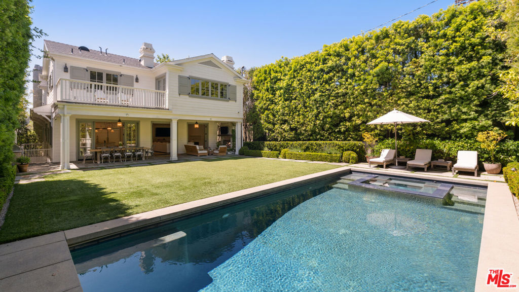 Set behind a gate on one of Brentwood's most coveted streets, this stunning 6-bedroom, 8-bathroom home blends timeless architecture with modern sophistication. Bathed in natural light, the interiors showcase exceptional craftsmanship, with custom millwork, wide-plank hardwood floors, and expansive windows framing views of the lush surroundings. The formal living room offers a serene gathering space with a stately marble fireplace, elegant coffered ceilings, and an adjacent office with a wet bar. The chef's kitchen is a true centerpiece, featuring dual islands, marble countertops, top-of-the-line appliances, and effortless flow into the open family room and out to the backyard. French doors throughout create seamless indoor-outdoor living, ideal for both relaxing and entertaining. Upstairs, you have four en-suite bedrooms, including the oversized primary with a balcony overlooking the yard. The primary bath features a separate shower and tub with two spacious walk-in closets. On the lower level, you'll find a private gym, home theater, temperature-controlled wine cellar, laundry, guest bedroom, and direct access from the garage into the house. The tranquil backyard is a private oasis with a sparkling pool, covered patio, and impeccably landscaped grounds framed by towering hedges. This extraordinary Brentwood residence offers refined living in a premier location where timeless design meets contemporary comfort. Just a short distance from the Brentwood Country Mart, the finest restaurants in Los Angeles, shopping, and much more!