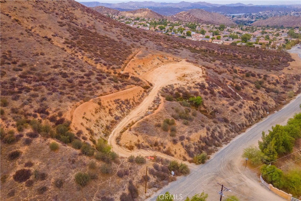 Welcome to Lost Road—where country living meets city convenience! This exceptional 5-acre vacant lot offers endless potential with a cleared and graded buildable pad already in place that is just shy of 1/2 acre. The pad, approximately 200 ft. (N-S) by 75–120 ft. (E-W), is ready for your custom home, with an unpaved driveway. A septic perc test (2015) and well location study (2015) have also been completed, giving you a head start on the building process.
The property showcases breathtaking 180-degree panoramic views of Canyon Lake, rolling hills, lush valleys, and the San Bernardino, San Gabriel, and San Jacinto mountain ranges. Enjoy sunrises, moonrises, and ever-changing scenic beauty right from your future doorstep.
Perfectly situated for families, this property is within walking distance to both an elementary and middle school, while still offering the privacy and tranquility of a rural setting. Just minutes away, you’ll find all the modern conveniences of shopping, dining, and entertainment. Plus, it borders the highly desired Canyon Hills neighborhood, adding to its desirability.
Whether you envision a peaceful retreat, family estate, or investment opportunity, this property delivers with its prime location, stunning vistas, and build-ready features.
Buyer to verify all information with the city and/or county for allowable uses and requirements. Buyer responsible for checking zoning, utilities, permits and property boundaries.