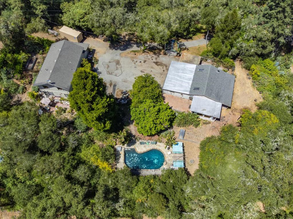 Nestled in the charming hills of Aptos, this unique property offers a blend of rustic charm and future potential. With an expansive lot size of 363,465 sq ft (8+ acres), this home provides ample space for outdoor activities and quiet country living. Home is a true fixer - appears to have solid bones - buyer would need to further investigate. The flooring features a mix of concrete and tile, adding to the home's distinct character. A cozy wood stove serves as the primary heat source, adding warmth and ambiance to chilly evenings. Additional amenities include a black-bottom, in-ground pool that promises endless summer enjoyment, and a 1800+ sq. ft. barn (built in 2001), perfect for storage or hobbyists. The property also features 2 useable flat acres in the lower lot (2 acres of sunflowers at one point:) It is located within the Pajaro Valley Unified School District, ensuring educational facilities are accessible. Although there is no formal dining room or family room, this home offers informal spaces for gatherings and family time. Find yourself in the heart of Santa Cruz County with beautiful beaches and endless outdoor adventures.