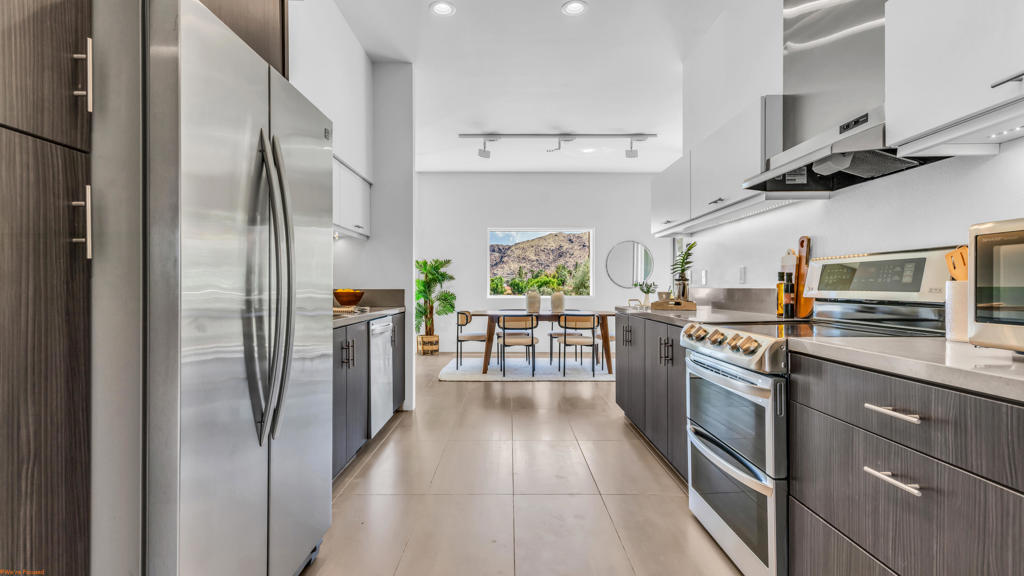 Exquisite mid-century modern residence in the prestigious Seven Lakes Country Club. This elegantly remodeled 2BD/2BA upper-level home showcases dramatic floor-to-ceiling glass, capturing sweeping views of the golf course and San Jacinto Mountains. Designer finishes include custom tilework, track lighting, and a chef's kitchen with premium appliances. The expansive sun porch offers seamless indoor-outdoor living.Enjoy exclusive access to the iconic William Cody-designed clubhouse featuring full-service dining, cocktail lounge, and curated social events. Community amenities include a Ted Robinson-designed 18-hole golf course, 15 resort-style pools and spas, tennis/pickleball courts, and 24/7 guard-gated security. A rare opportunity to experience elevated desert living in one of Palm Springs' most architecturally significant communities.