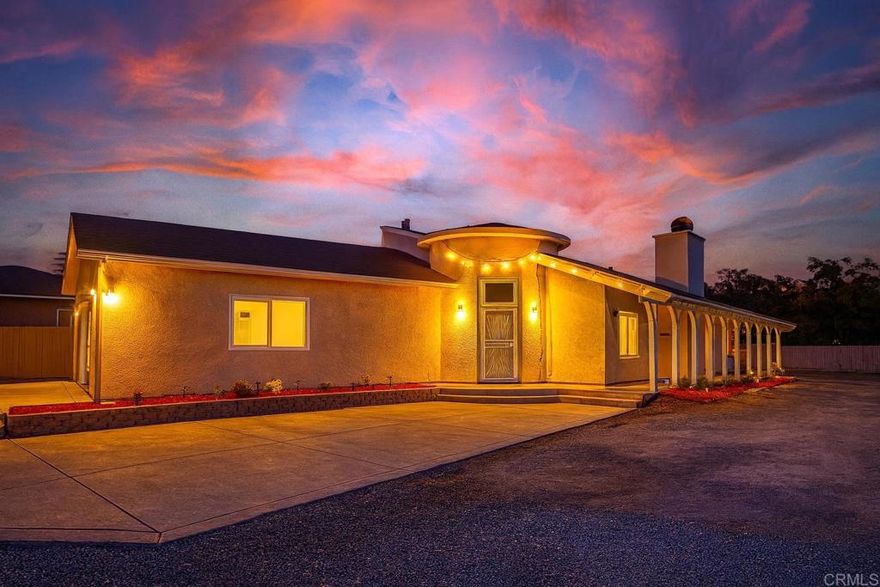 Fully renovated 4 bedroom, 2.5 bath single-level home built in 2020 with 2,289-SqFt, attached garage and fully usable .56-acre lot. Step inside to a light-filled, open concept living space with soaring ceilings and a modern, streamlined aesthetic. The interior has been completely reimagined with sleek white walls and high-gloss marble flooring, giving the home a crisp, contemporary feel. The gourmet kitchen is a standout, featuring a dramatic waterfall island with richly veined stone, dual-tone cabinetry, stainless appliances, and a layout that flows beautifully into the living and dining areas. The fireplace, clad in elegant tile, anchors the spacious great room, while recessed lighting enhances the clean, modern lines. The primary suite is a serene retreat with luxurious ensuite bath featuring dual sinks, deep soaking tub and oversized steam shower. The additional bedrooms are generously sized and share access to a full hallway bath. A cleverly placed half bath off the living area enhances functionality for guests. All bathrooms have been upgraded with timeless tile work, modern vanities, and high-end fixtures. Outside, the expansive lot offers tremendous potential with plenty of space for a large pool, multiple ADUs and more. The gated circular driveway and open yard space make parking, storage, and expansion easy. This home is perfect for buyers seeking modern design with privacy and a convenient location near shopping, restaurants, schools and freeway access. Don’t miss your chance to make this turnkey beauty yours. Some photos have been virtually staged.