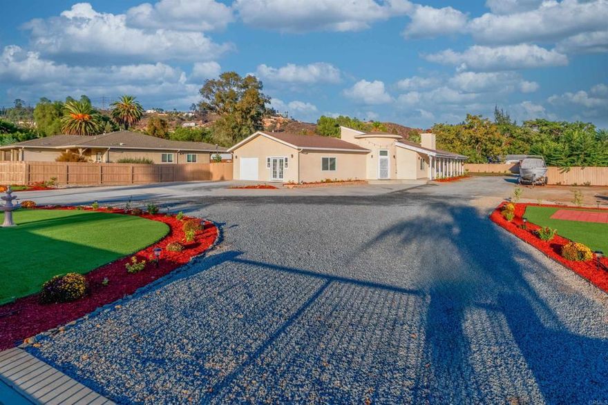 Fully renovated 4 bedroom, 2.5 bath single-level home built in 2020 with 2,289-SqFt, attached garage and fully usable .56-acre lot. Step inside to a light-filled, open concept living space with soaring ceilings and a modern, streamlined aesthetic. The interior has been completely reimagined with sleek white walls and high-gloss marble flooring, giving the home a crisp, contemporary feel. The gourmet kitchen is a standout, featuring a dramatic waterfall island with richly veined stone, dual-tone cabinetry, stainless appliances, and a layout that flows beautifully into the living and dining areas. The fireplace, clad in elegant tile, anchors the spacious great room, while recessed lighting enhances the clean, modern lines. The primary suite is a serene retreat with luxurious ensuite bath featuring dual sinks, deep soaking tub and oversized steam shower. The additional bedrooms are generously sized and share access to a full hallway bath. A cleverly placed half bath off the living area enhances functionality for guests. All bathrooms have been upgraded with timeless tile work, modern vanities, and high-end fixtures. Outside, the expansive lot offers tremendous potential with plenty of space for a large pool, multiple ADUs and more. The gated circular driveway and open yard space make parking, storage, and expansion easy. This home is perfect for buyers seeking modern design with privacy and a convenient location near shopping, restaurants, schools and freeway access. Don’t miss your chance to make this turnkey beauty yours. Some photos have been virtually staged.