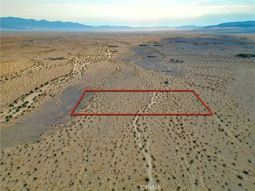 Versatile 5-acre flat parcel (APN #0628-021-40-0000) located just minutes from town, with nearby road access via Sullivan Rd. Utilities are in the area, with electricity at neighboring lots and water reported at depth in the region (buyer to verify availability). Conveniently located across from the national park and near the 29 Palms airport. Buyer to conduct independent investigations regarding zoning, permitted uses, and development potential.