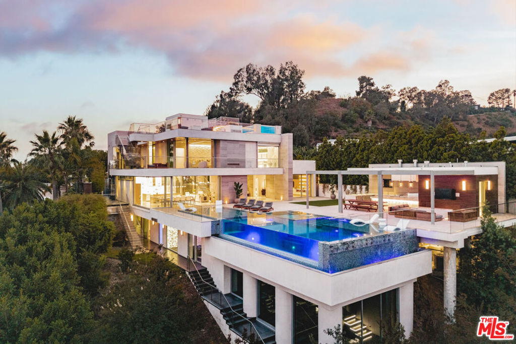 Modern Sanctuary of Unrivaled Luxury, Wellness & Iconic Views! Perched atop the most prestigious promontory in Beverly Hills, "The Retreat at Laurel" is a rare architectural masterpiece offering over 16,000 square feet of refined indoor-outdoor living. Rare, nearly 360 Views of the Pacific Ocean, LA Basin, and Franklin Canyon Park. Tucked at the end of Laurel Way, this ultra-private compound captures sweeping views from Downtown Los Angeles to the Pacific Ocean. With neighboring Franklin Canyon Park as a backdrop and just minutes from Rodeo Drive and the Beverly Hills Hotel, it offers a unique blend of seclusion and prime location. Built with precision and vision, the residence showcases eight bedrooms and fifteen bathrooms, framed by dramatic lines, soaring ceilings, and floor-to-ceiling glass that brings in natural light and world-class vistas from every angle. The expansive outdoor areas include two spectacular pools, an infinity-edge Baja shelf pool overlooking the city, and a glass-walled rooftop pool above the primary suite. A covered outdoor kitchen and bar, multiple fire features, and an amphitheater create the ultimate backdrop for entertaining. Inside, a chef's dream kitchen with two islands, a walk-in pantry, and three additional kitchens (prep + two outdoor) make hosting effortless. Two state of the art movie theaters offer cinematic luxury. Indoor and an open-air amphitheater that could be used as a recording studio. Wellness takes center stage with a full spa suite featuring a custom gym, massage room, meditation lounge, juice bar, two saunas (steam and dry), and an indoor hot tub, all curated to evoke a five-star resort experience. Both pool house and master bath showers have steam A floor-to-ceiling glass wine cellar with a tasting room awaits the most discerning collector. Additional highlights include a glass elevator, hidden vaulted safe room, four-turntable garage for up to ten vehicles, golf hole, and sports court. Every detail of The Laurel Estate has been thoughtfully crafted to offer a lifestyle of elegance, well-being, and awe-inspiring beauty in one of the most iconic locations in Los Angeles.