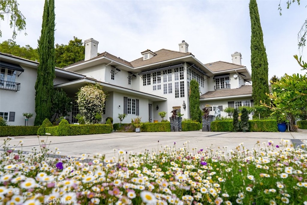 Set in one of California’s most desirable Central Coast regions, this 33± acre estate offers elegance, serenity, panoramic views, and unmatched pride of ownership. Surrounded by lush redwoods, fruit trees, and manicured gardens, the gated and fully fenced property features a Monet-inspired lagoon, koi pond, Japanese meditation house, grotto waterfall, treehouse, and dedicated gym/game area—creating a peaceful, storybook setting. At its heart lies a 7,200± sq. ft. Hampton-style main residence with 5 bedrooms, 6 bathrooms, and a separate en-suite with private balcony. Interiors showcase cherry hardwood floors, exotic stone, and 4 fireplaces. The gourmet kitchen includes high-end appliances, butler’s pantry, and designer lighting. Recent upgrades include new hardwood floors, roof, fencing, 3 HVAC systems, pavers, and a 60-panel solar system. Outdoor amenities include an infinity pool/spa with Tuscany-like views, full kitchen, grill, and fireplace. A separate 2,800± sq. ft. guest house with 4 beds/3 baths, 2 barns, horse stalls, and a 300-tree pomegranate orchard add function and flexibility. One barn offers event venue potential. With 4 wells (2 in use) and close proximity to town, this rare legacy property combines privacy, timeless sophistication, and lifestyle or business potential.