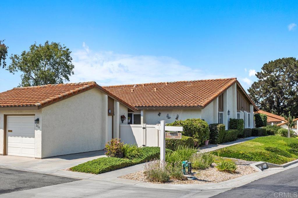 This single level 3 bedroom end unit has 2 spacious patios to enjoy outdoor living with open views and privacy. In addition to the attached one car garage there is a reserved parking space next to it. The house features a remodeled open kitchen design that includes a center island work station and dining area with sliding doors opening on to a delightful garden patio with mountain and greenbelt views along with blooming flowers and an assortment of citrus trees. The living room has wood floors, vaulted ceilings, crown molding and plantation shutters throughout. All 3 bedrooms are a nice size with a built-in murphy bed in one making it a perfect guest room/ office combination! The primary bedroom has a walk it closet and its own private garden patio. Gas forced air heat and air conditioning for comfort year round. High Country Villas is an age restricted community that offers the ultimate in active senior living. This home is close to guest parking and only a block to the recreation area offering a clubhouse with monthly dinners, frequent events, an assortment of clubs to join, game nights, 2 pools heated year round, tennis courts, pickle ball, a 9 hole golf course, and walking trails. Centrally located in the middle of Encinitas close to shopping, restaurants, medical facilities, specialty shops, the Coaster, with easy access to I-5 and only 3 miles to famous Moonlight Beach.