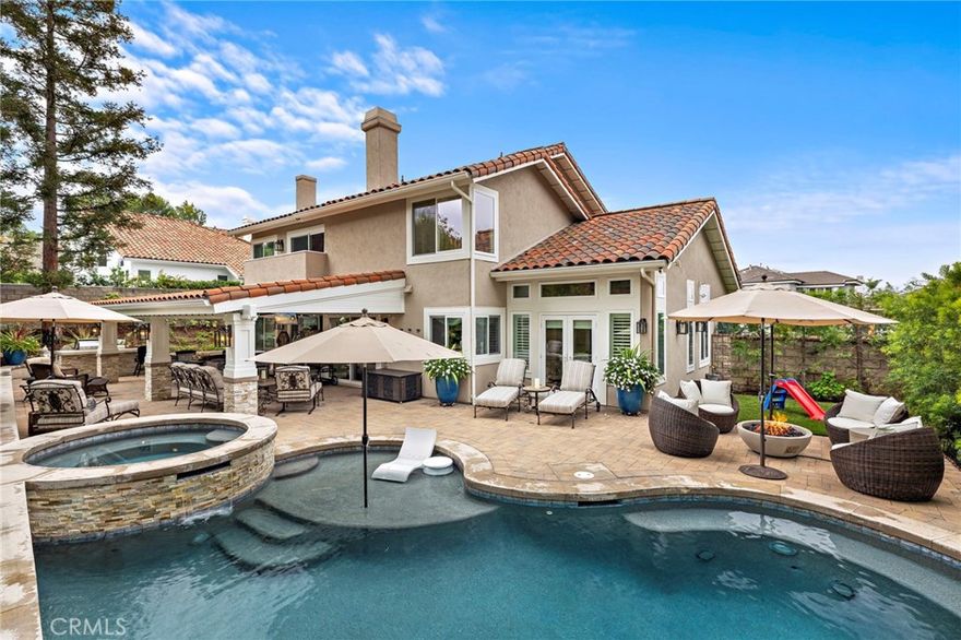 A remarkable home that has been completely and thoughtfully reimagined from top to bottom. Set on an oversized corner lot within Mission Viejo’s prestigious guard-gated community of Canyon Crest, this COMPLETELY REMODELED 5-bedroom, 3-full bath residence with a 4-car garage offers a perfect blend of modern comfort and exceptional outdoor living. The open-concept floor plan includes the convenience of a main-floor bedroom and bath ideal for guests or a home office. The heart of the home is a fully remodeled kitchen featuring custom cabinetry with pull-out storage, an expanded island, and Bosch stainless steel appliances—seamlessly connecting to the family room with its custom-built cabinetry, beverage center, and new wood fireplace mantel accented by a tiled façade. Hardwood flooring flows throughout the main level, complemented by freshly installed carpet upstairs and custom window treatments throughout. The primary suite has been thoughtfully reimagined with a shiplap accent wall, updated fireplace with new wood mantel and tiled façade, remote-control blinds, and a completely remodeled spa-inspired bathroom including a dual sink vanity, a TOTO smart bidet toilet, and a large walk-in closet with Closet World organizers. Upstairs, the secondary bedrooms feature remote-control blinds and share a beautifully updated hallway bath, while the bonus room or fifth bedroom provides additional flexibility for living or recreation. The outdoor living experience rivals a private resort. A saltwater Pebble-Tec pool and spa anchor the rear yard, surrounded by interlocking pavers, low-maintenance turf, and beautifully designed landscaping. The impressive, covered patio structure includes two ceiling fans, electric heaters, a beverage refrigerator, ice maker, and mounted TV—perfect for hosting gatherings, watching the big game, or relaxing poolside. A built-in BBQ island and dedicated trash enclosure complete this entertainer’s dream. Additional highlights include; Whole house Pex Piping, new dual-pane windows and French doors, new HVAC system, remodeled laundry room, built-in garage cabinetry, and access to Canyon Crest’s exceptional amenities—three community pools, spa, clubhouse, fitness center, tennis and pickleball courts, plus membership to Mission Viejo Lake.