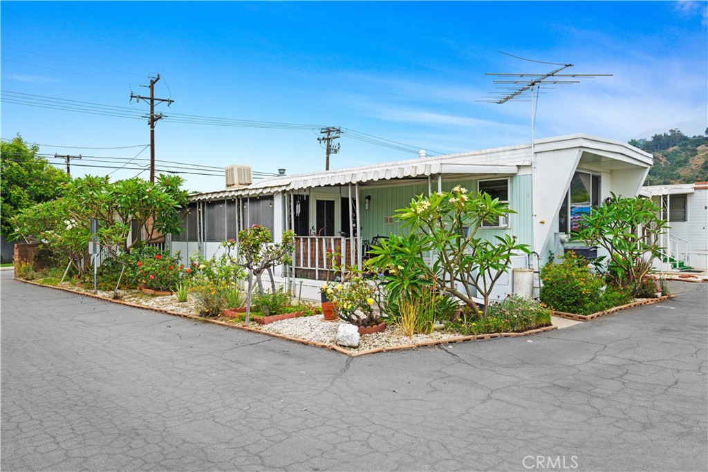 This single-wide mobile home is located in a senior community and features one bedroom and one bathroom, including a walk-in shower. The house is equipped with a swamp cooler for cooling during the warmer months. Additionally, it features an enclosed patio with windows, where the washer and dryer are located, as well as two storage units. The community offers amenities, including a clubhouse and a swimming pool, for residents to enjoy.