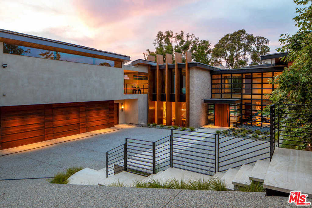 A warm modern masterpiece, this ultra-private, gated residence in Brentwood was thoughtfully envisioned to seamlessly integrate indoor and outdoor living. Designed by architect John Andrews, the residence showcases a masterful blend of glass, steel, stone and wood, while perfectly positioned to maximize views of the surrounding nature. Encompassing two flat home sites totaling nearly an acre, the 13,386-square-foot residence sets a dramatic tone from the moment of arrival.