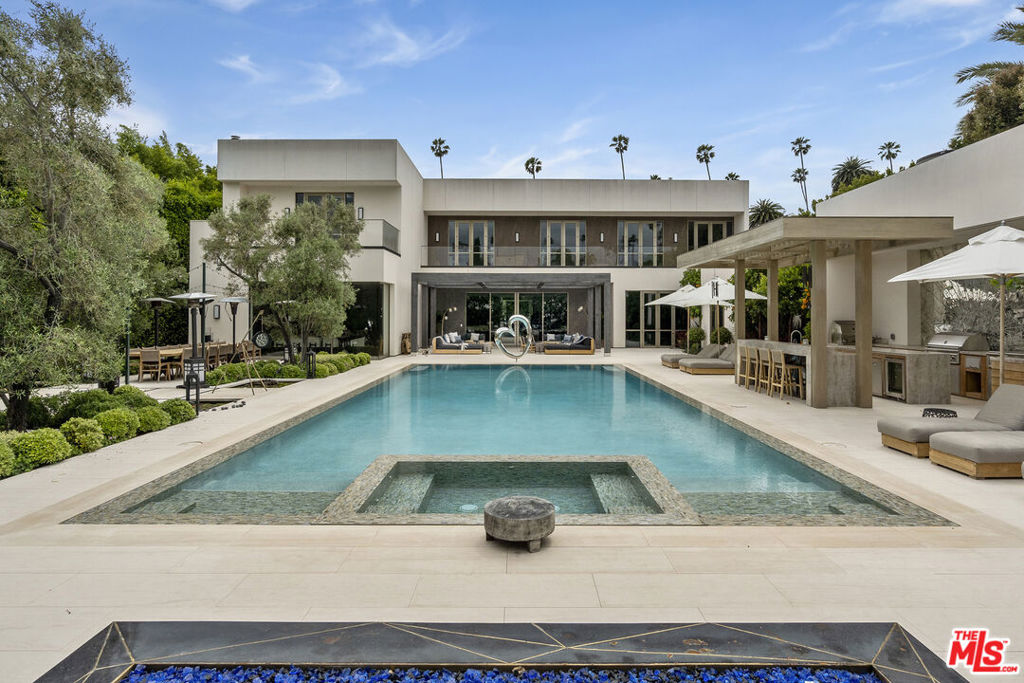 Luxury living at its finest in prestigious Beverly Hills Flats. Once graced by Jackie Collins, this iconic estate exudes elegance and sophistication. Italian marbles, bespoke woodwork, and Miele appliances adorn the expansive interior. Sustainability meets luxury with solar power and a generator. Elevator access, dual garages, and sprawling living spaces offer convenience. The master suite boasts indulgence, while entertainment options abound. Outside, a tranquil oasis awaits with a pool and hot tub. With seven bedrooms and ten bathrooms, pool bath and 3 powder rooms, this estate defines Beverly Hills luxury living.