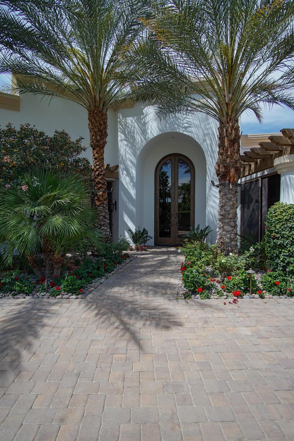 THE ESTANCIAS: **IF IT'S UP, IT'S AVAILABLE. CURRENTLY AVAILABLE ALL MONTHS** This stunning Mediterranean custom home offers breathtaking snow-capped mountain views and impressive 15-foot arched entry doors. The interior is bright and open, with soaring ceilings and striking architectural details. Stone floors and walls of glass flow through the living, dining, kitchen, and family rooms, creating an elegant and airy atmosphere. The living room is spacious and refined, while the sit-down wet bar includes a fridge, dishwasher, and panoramic views of the mountains and pool. The great room boasts a walk-in wine room fully clad in stone. The chef's kitchen is equipped with Sub-Zero and Wolf appliances, rich wood cabinetry, and granite counters. The primary suite features a fireplace, mountain views, a large walk-in closet with island, and a luxurious bath with marble surfaces, dual water closets, and electric shades. Two guest suites offer private baths, and a generous office overlooks the garden. Outside, a 75-foot pool with boulder waterfalls, lush landscaping, and a brick paver patio create a resort-like setting.
