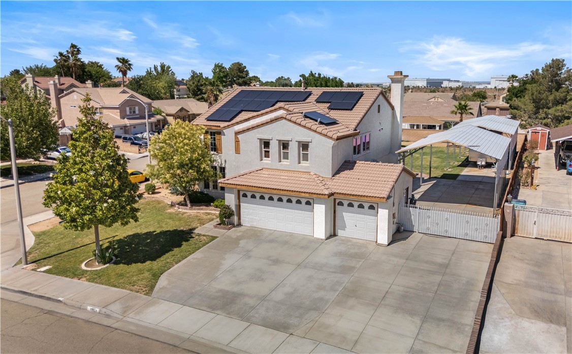 OWNED SOLAR! This spacious and upgraded Palmdale home sits on an expansive 15,000+ square foot lot in a fantastic neighborhood right next to the Antelope Valley Country Club. Featuring four bedrooms and three bathrooms—including a full bedroom and bathroom on the main level—this home is perfect for multi-generational living, accommodating guests, or creating a private home office. Inside, you'll find new flooring throughout and a thoughtfully designed layout that provides both comfort and flexibility. The heart of the home includes open living areas and a well-appointed kitchen, ideal for everyday living and entertaining. Upstairs, a large loft offers even more space for a secondary living room, game room, home gym, or media center. The 3-car attached garage is complemented by an oversized driveway and a remote-operated side gate that opens to an impressive 80 feet of covered parking—complete with 30-amp power and a sewer hookup, making it an ideal setup for RVs, boats, or work vehicles. Step into the backyard and enjoy west-facing afternoon shade, perfect for relaxing or hosting gatherings in the warm summer months. The property also features mature fruit trees—including nectarine, peach, plum, and apple—providing fresh produce and a touch of nature. A generously sized enclosed storage facility offers extra space for tools, equipment, or hobby use, giving you all the room you need to stay organized. The home is equipped with a high-performance, American-made solar system that is fully owned, providing significant savings and long-term value. Located just minutes from the 14 Freeway, local schools, shopping centers, and major defense contractors, this home offers the perfect blend of convenience and lifestyle. Don't miss the chance to own this one-of-a-kind property—schedule your private showing today!