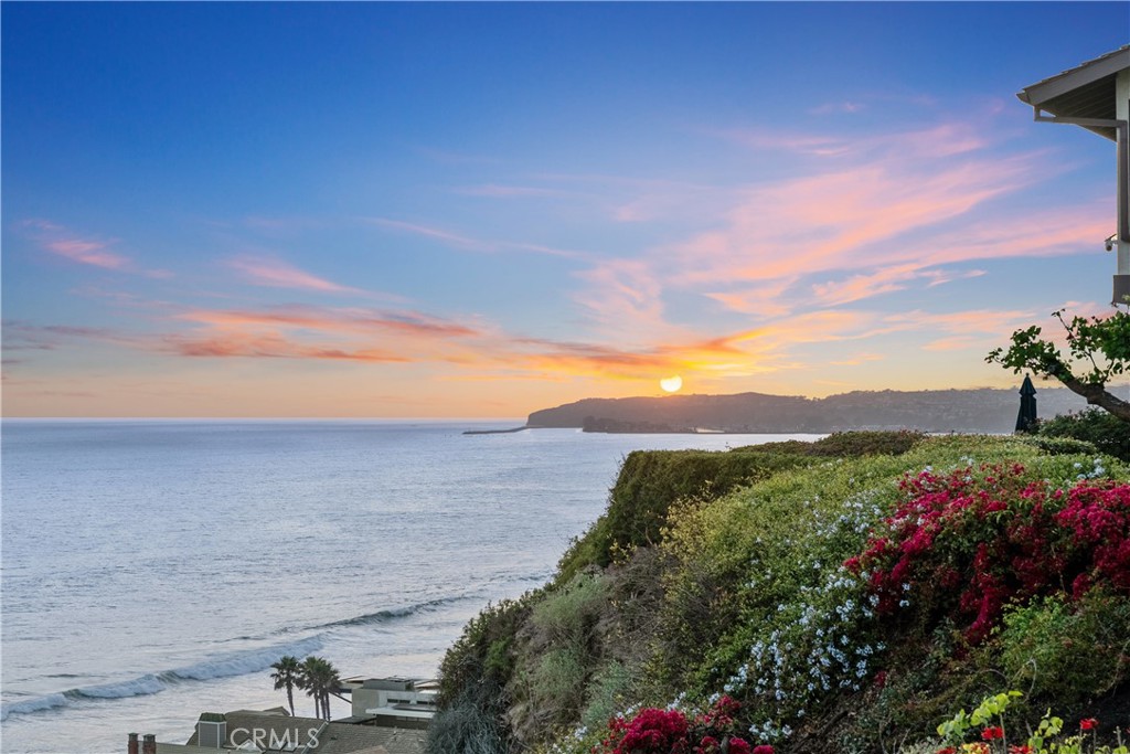 Come hear the waves... Step into coastal luxury with this stunning seaside property nestled atop the scenic bluffs of Capistrano Beach. This expansive, nearly 4,380-square-foot home offers an unparalleled living experience defined by the ever-changing panoramic views while hearing the sound of the Pacific Ocean and enjoying views of Dana Point Harbor. Blending timeless elegance with modern convenience, the home boasts 4 ensuite bedrooms plus 2 half baths, a fifth bedroom is currently being used as an office. The home includes a gourmet chef’s kitchen with premium appliances, a large island, and a walk-in pantry. The adjacent dining room and living room open onto an expansive rear deck and offer commanding views of the ocean, providing a striking backdrop for relaxation or entertaining. A large ocean view laundry room and cozy den complete the first level. Take the stairs or the elevator to the second floor and find two primary and two large secondary bedrooms, each with vaulted ceilings and ensuite bathrooms. The second level also features a spacious office with a walk-in closet and a fabulous great room with ocean views and a stylish wet bar. Two garages provide parking for three cars, plenty of storage, and space for a workshop. The estate is ideally situated near the Dana Point Harbor and the Dana Point Lantern District, and the world-famous Trestles surf spot. This is coastal living at its most inviting.