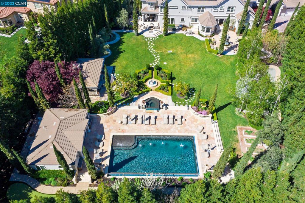 Brokers Tour: 7/28 10 - 2PM! No property compares to this iconic & famous gated estate nestled on an exclusive and private flat 1.56 acres! Come walk the grounds of this entertainer’s paradise. Experience for yourself the lavish primary suite, with four elegant en-suite bedrooms, chef's kitchen, formal lounge, wine cellar, and media room. Working from home? Enjoy the grand executive office with a fire place. Past remodels boast wide plank oak flooring, chefs kitchen, lighting features & primary suite. This idyllic setting and collection of fruit trees and flora compliments a 25x50 ft infinity pool, vanishing edge spa, cabana, putting green, playhouse & guest house with sauna. Sprinkled throughout the grounds are French sculptures, fountains, outdoor fireplace and a fire pit. A 6 car garage & extensive off street parking allows an extra 10+ cars. Located in the most prominent, secure blocks in Alamo & surrounded by award winning schools, parks, dining, shopping & country clubs.