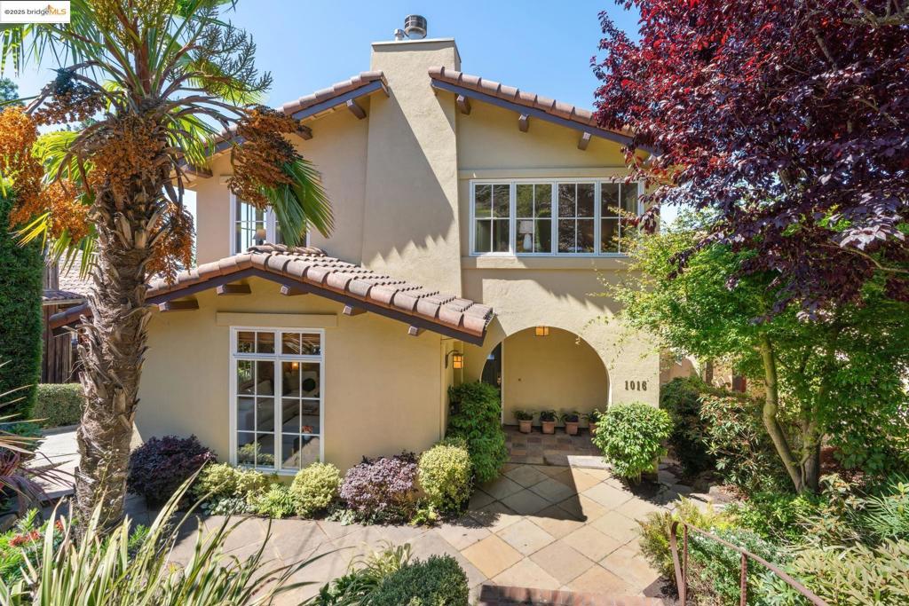 With sweeping Bay and Bridge views and curated gardens, this sunlit Mediterranean home offers four bedrooms, two and one-half baths, and elegant living across expansive spaces. Built in 1998, it begins with a landscaped courtyard bordered by dry-laid stone walls. Formal dining and living rooms frame mesmerizing vistas, with French doors opening to a terrace and an arbor-shaded deck. The living room features a marble fireplace and hardwood floors that continue through the culinary kitchen and family room with a second fireplace. The kitchen includes a center island, pantry, and eat-in area designed to take in the view. Upstairs, the home continues to impress with four generous bedrooms and two well-appointed baths. The layout, thoughtfully arranged for privacy—several enjoy outlooks to the Bay—culminating in the expansive primary suite with vaulted ceilings, dual closets, and the quiet pleasure of awakening each morning to unforgettable horizons. The lower level offers space for an office & lounging, a two-car garage with interior access, and abundant storage. Experience a life framed by nature’s beauty, where the deep, exquisitely designed garden reveals vibrant color, thoughtfully planted to create both lushness and architectural interest—ideally situated for nature enthusiasts.