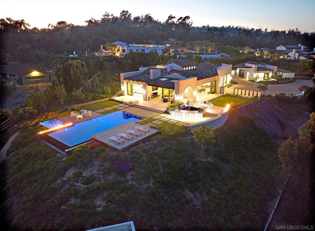 Welcome to 4803 Linea del Sol, where the tradition and elegance of Rancho Santa Fe meets the modern, coastal atmosphere of Del Mar. This magnificent hacienda-inspired home, built in 2020 by renowned builder Greg Agee, offers 6,351 square feet of living space on a 2.5 acre lot with panoramic ridgeline views of Rancho Santa Fe, Carmel Valley and Del Mar. The scale and grandeur of this estate is something truly to marvel. Experience unparalleled luxury and privacy as you’re greeted with your own gated entrance leading to an expansive stone paved courtyard and 5 car garage. The main residence features 6 ensuite bedrooms each with their own private patio access, 2 powder bathrooms, including a detached ensuite casita. As you step through the beautifully designed arched glass paneled front door, the property commands an immediate breathtaking moment with its striking indoor to outdoor-views that flow seamlessly from the kitchen to the outdoor entertainment area. The heart of the home, the kitchen, is adorned with an oversized Mont Blanc quartzite island with bar seating, creating the perfect setting for hosting. The living room is surrounded by floor to ceiling glass doors with an open invitation to the outdoor living room with its very own fireplace. The dining area beautifully accentuates the great room and pairs nicely with an 800 bottle wine cellar and entertainers bar. The outdoor space is nothing short of jaw dropping, featuring an oversized PebbleTec infinity pool and spa with built-in fire features. Experience unparalleled luxury and privacy as you’re greeted with your own gated entrance leading to an expansive stone paved courtyard and 5 car garage. The main residence features 6 ensuite bedrooms each with their own private patio access, 2 powder bathrooms, including a detached ensuite casita. As you step through the beautifully designed arched glass paneled front door, the property commands an immediate breathtaking moment with its striking indoor to outdoor-views that flow seamlessly from the kitchen to the outdoor entertainment area. The heart of the home, the kitchen, is adorned with an oversized Mont Blanc quartzite island with bar seating, creating the perfect setting for hosting. The living room is surrounded by floor to ceiling glass doors with an open invitation to the outdoor living room with its very own fireplace. The dining area beautifully accentuates the great room and pairs nicely with an 800 bottle wine cellar and entertainers bar. The outdoor space is nothing short of jaw dropping, featuring an oversized PebbleTec infinity pool and spa with built-in fire features. The backyard is complete with a large quartzite island, BBQ, and bar seating area making this an ideal haven for hosting gatherings under the San Diego sunsets. Every detail has been meticulously curated for the ultimate luxury experience. This magnificent property is uniquely situated to enjoy both the prestigious amenities of the Rancho Santa Fe Covenant, and the benefits of the Del Mar address. The property is annexed into the covenant with an option for golf membership at the highly sought after Rancho Santa Fe Golf Club. Delight in this secluded retreat style estate, while only being minutes from top dining, shopping, and beaches. Embrace the unparalleled comfort and lifestyle of Linea Del Sol, and live every day as your own vacation.