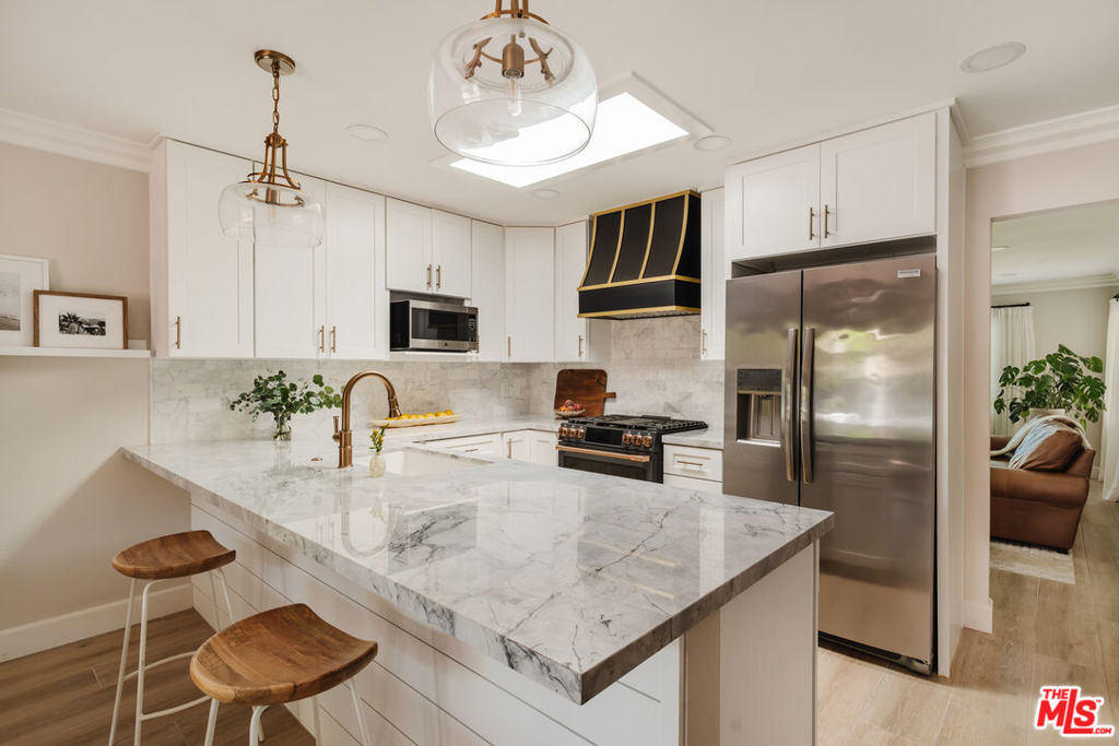 Welcome to 2641 Hartland Circle a stylishly updated 2 bed, 2 bath single-level home in the heart of Westlake Village, with only one shared wall and your own private outdoor escape. Inside, you'll find a bright, thoughtfully redesigned kitchen with quartz counters, a custom range hood, wine fridge, and skylight. The breakfast bar flows into the dining area, where French doors open to a dreamy brick patio wrapped in string lightscomplete with built-in BBQ, turf lounging area, and space for your pup to play. The living room is cozy and curated, featuring a classic fireplace, crown molding, and plantation shutters. The primary suite includes an en-suite bath and direct access to a covered patio for morning coffee. Additional upgrades include brand new European oak-style porcelain tile floors, newer HVAC, and a finished 2-car garage with epoxy floors, custom cabinetry, and a new washer & dryer. Enjoy two community pools, lush greenbelts, and unbeatable proximity to top-rated schools, shopping, dining, and trails. Move-in ready and full of charm - this one feels like home.