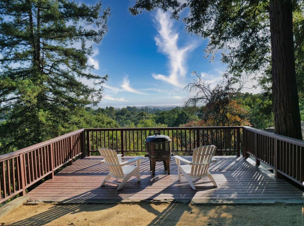 Magnificent Views. Exceptional Privacy. Endless Potential. You'll feel secluded in the hills but conveniently access all of Silicon Valley from this enchanting home on a quiet cul-de-sac in sought-after Emerald Hills. On a huge 18,820 sf lot w/numerous mature trees and breathtaking views overlooking the lake & SF Bay. Historic charm with modern comforts: vaulted ceilings, wood-burning fireplace, spacious dining area w/bay window, chefs kitchen w/shaker cabinets & ample counter space, all in an open layout with gleaming hardwood floors. Master bedroom suite has treetop views & luxurious steam shower. New balcony deck spans living & bedroom areas. Den has built-in projector & screen. New carpet and interior staircase. Central forced heat & recessed lighting throughout. Entertain, play, or garden outdoors on several flat areas & new upper deck. A detached 225 SF structure is ideal as a home office, studio, or potential ADU. Unlock more financial potential with an SB-9 lot split: sell one of the two parcels, before or after further developing it. Or use the large property size to expand (or rebuild) the main house, keeping the park-like grounds for yourself & your landscaping dreams. Zoned for award-winning Roy Cloud School. Minutes from parks, hiking, golf, downtown Redwood City.