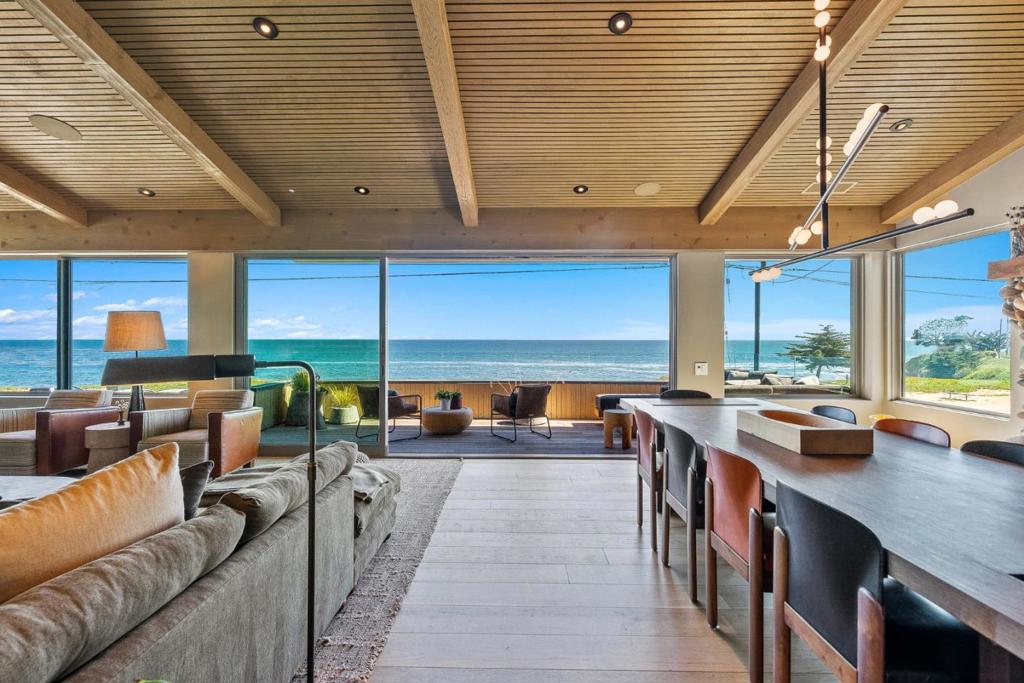 Panoramic ocean views and world-class design meet in this front-row West Cliff Drive masterpiece by Marmol Radziner, the acclaimed architectural firm celebrated in Architectural Digest's AD100. Designed with a reverse floor plan to capture sweeping horizons, the home features floor-to-ceiling windows and multi-slide glass doors. Imagine watching whales glide by, sipping cocktails on your deck while soaking in breathtaking sunsets, or taking just steps to the sandy shores of Mitchells Cove Beach. Embrace a healthy lifestyle with nearby biking trails, coastal strolls, and endless opportunities for outdoor living and recreation. This home is a very rare find, featuring an open-concept living space, custom millwork, hardwood floors, a large island, a chef's kitchen, and top-quality materials. Four ensuite bedrooms include a spacious and comfortable primary suite. Outside, your backyard oasis offers al fresco dining on an expansive deck with an outdoor kitchen. Host gatherings at the backyard bar with built-in BBQ and keg tap, unwind by the cozy gas fireplace lounge and outdoor TV, refresh in the outdoor shower, or rejuvenate in the private sauna. This exceptional property blends luxury and comfort, modern architecture, and the vibrant coastal lifestyle of Santa Cruz's Lower Westside.