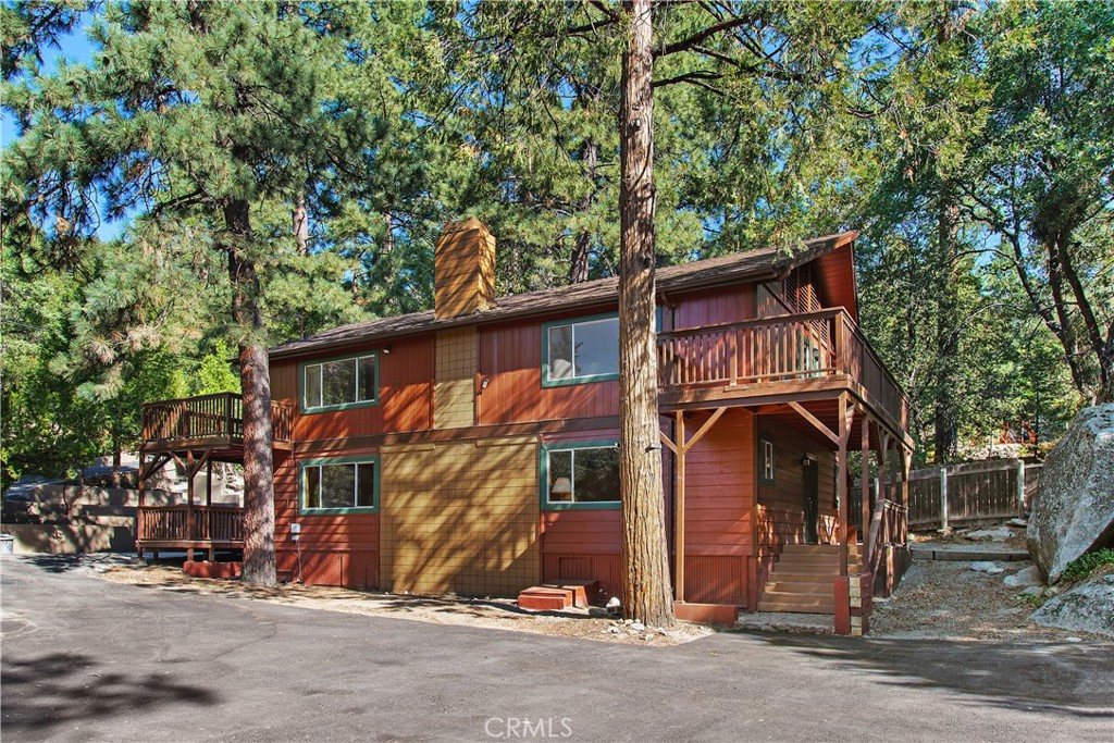 Presenting an attractive Cedar Glen duplex-style retreat with a private driveway bringing you below the main street level. The property features an ample parking pad adjacent to the residence for convenient access. The home comprises two identical units sharing a single wall, each with its own private entrance. Each of the units offers 2 bedrooms, 1 full bath, a fireplace, an updated kitchen, and a spacious second-story balcony. With just over 1,100 square feet of living area in each unit, there is plenty of room to enjoy these fully renovated spaces. You can live in one unit and rent the other, or rent both for maximum income. Custom-installed hickory wood flooring lends a warm, mountain-inspired atmosphere throughout the interiors. The kitchens are enhanced with butcher block countertops, new hickory cabinetry, modern appliances, and updated sinks. The living areas benefit from newly refinished, tongue-and-groove pine walls, a pine coffered ceiling, a wood-burning fireplace, and an open floor plan, creating a bright and welcoming environment. Upstairs, residents will find new stackable washers and dryers on the landing and access to the expansive balconies. The bedrooms feature hickory flooring, mirrored closet doors, and scenic views of the surrounding forest. The rooms are generously sized and receive ample natural light. The bathrooms have also been updated with new vanities and tile in the shower/tub enclosures. The exterior grounds include a patio area and terraced stairs leading from the street level. The sale includes the adjacent lot, offering a total of approximately two-thirds of an acre. A seasonal creek runs on the back side of the property, providing a serene natural setting. The Idyllwild Nature Center is located just beyond the property lines, with Nature Center trail access from the property and Suicide Rock trail access just across the road. The Downtown Village of Idyllwild—featuring shops, restaurants, breweries, and wine bars—is only minutes away by car or a beautiful forest hike via Nature Center trails. This property offers a unique opportunity to experience the tranquility and charm of a mountain village environment.