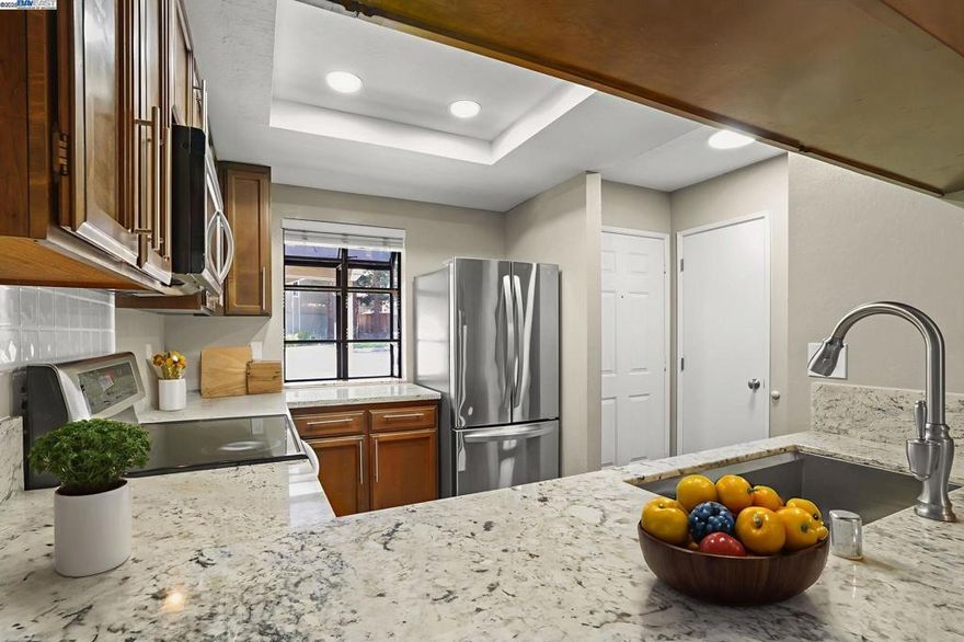 OPEN Sunday 1:00-4:00 10/5. Move in ready! Priced to sell! Motivated seller! Bring your offer! Step into this beautifully updated Eastgate townhome-style condo, where comfort meets style in every corner! With 2 spacious bedrooms — one with its own private balcony — and 1.5 baths, you’ll love the smart use of its 1,088 sq ft layout. The modern kitchen shines with stone countertops, stainless steel appliances, a cozy breakfast bar, and a sunny garden window. Enjoy the open-concept living and dining area, complete with a charming fireplace and a slider that opens to your own private patio nestled under redwood trees with no neighbors behind. Plank flooring, central heat and air, plus a stackable washer/dryer add everyday ease, while double-wide bedroom closets and extra storage keep life organized. Relax by the community pool or clubhouse, with HOA perks like water, trash, landscape and building upkeep included. With two parking spots, guest parking, and a prime spot near parks, trails, downtown Martinez hotspots, and quick freeway access — this Eastgate condo is ready to welcome you home!