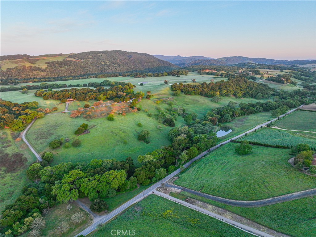 Experience the rare opportunity to own one of Paso Robles’ most exceptional legacy properties, 216+/- acres of pristine, usable land located in the heart of the highly sought-after west side along scenic Vineyard Drive. Once the private retreat of a renowned actor, this iconic estate offers an extraordinary blend of natural beauty, rich history, and unmatched amenities.
Privately nestled among gently rolling hills and expansive pastures, the property is dotted with ancient oak trees, mature walnut trees, and natural flora, creating a peaceful and visually captivating environment. Designed with versatility, the land is fenced for agriculture and features multiple water sources, including reservoirs and seasonal creeks.
One of the most distinctive aspects of the estate is its private airstrip and two aircraft hangars—a rare and increasingly difficult feature to replicate, offering direct aviation access for effortless arrivals and departures.
Improvements on the property are both abundant and thoughtfully positioned. The 5,022± sq. ft. main residence serves as a private sanctuary, with the entire upper floor dedicated to a primary suite that overlooks the surrounding hills and vineyards. The 1,129± sq. ft. guest house includes a wine cellar and game room, ideal for entertaining. A separate 1,126± sq. ft. manager’s quarters offers flexibility for staff, multigenerational living, or rental income.
Additional structures include barns/workshops, equipment storage and horse stalls, making the property well-suited for equestrian use, ranching, or other agricultural endeavors. The land’s topography and soil also lend themselves well to vineyard development, especially given its location within the renowned Templeton Gap AVA—known for its coastal breezes, and ideal growing conditions.
The ranch is also enrolled in the Williamson Act, helping preserve its agricultural heritage and offering substantial property tax advantages.
Whether you’re seeking a serene family compound, a working ranch, a destination-worthy wine country retreat, or an aviation-accessible legacy estate, this property offers a rare combination of character, functionality, and natural splendor.
Surrounded by world-class wineries and just minutes from the acclaimed tasting rooms, restaurants, and boutique shops of downtown Paso Robles, this one-of-a-kind offering must be seen to be fully appreciated. Schedule your private tour today and discover the soul of the Central Coast.