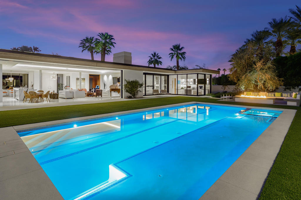 Just completed spectacular modern renovation at the Vintage Club! Five bedrooms including a two bedroom guest house plus office, five and a half baths. Approx. 7,112 sq. ft. on oversized .87 acre lot. Faultless frontage with beautiful desert landscaping and artificial turf accents. Elegant foyer to great room with linear fireplace, formal dining with custom glass wall wine display and a fully equipped bar that's out of this world! Sleek modern gourmet kitchen and morning room opens to loggia with dining and media. State of the art home theater features custom wet bar with beverage refrigerator and confection display. Envious office with opening walls of glass, stunning master suite with fireplace and guest house with two bedrooms and two full baths. This solar powered home is totally remodeled with disappearing walls on the entire back that open to the most incredible outdoor entertainment area which is an event in the making featuring a custom swimmers pool with tanning shelf, inlaid spa, custom fire pit with seating area and resort like accommodations your guests will surely enjoy. This ultra-private estate has every amenity and is a must see property! Furnished per inventory.