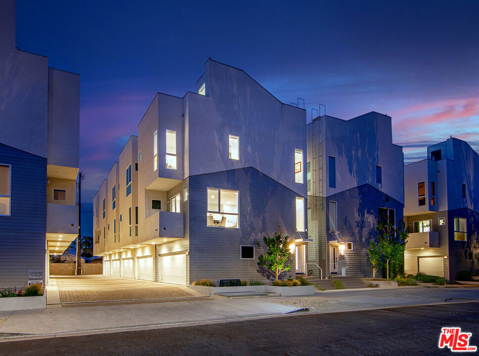 This stylish multi-level home features high ceilings, tons of oversized windows and a seamless, open floor plan offering an indoor/outdoor lifestyle. Enter through the garage, or the front door to the first level, which features the first bedroom, which can be used as an office. The second floor features an open concept living room and an open island gourmet kitchen, boasting Bertazzoni appliances, waterfall quartz counters, and abundant cabinetry. The third level offers two generous ensuite bedrooms, including a luxurious primary suite with custom dual sink vanity, a large shower with soaking tub and walk-in closet. Enjoy panoramic city and hill views on the spacious private rooftop deck including water and gas hookups. Additional features include an attached, private two-car garage with direct entry, private balcony and enclosed patio, powder room, tankless water heater, full size washer and dryer, and dual zone AC/heat. There are countless upgrades to the home, some of which include: whole-house water filtration system, including charcoal and salt-free water conditioner, rain head primary shower, Wired for bidet in primary bath, with other bathrooms wired for bidets. The windows have Lutron electric window coverings on all street-facing windows, many with two shades - both sheer and blackout, hardwired, precluding the need for batteries. The entire house has "smart home" features (none of them require internet or cloud connectivity) including Control4 system with 3 in-wall controls, Lutron light controls (RadioRA 3 and Caseta), In-ceiling Sonos architectural speakers in living room (TV surround sound), Unifi Protect security camera system, including video doorbell, Unifi Enterprise-grade wifi system, Yale Zigbee-based Smart Lock on front door and USB charging outlets in the bathrooms. Welcome to California living at its finest in this exquisite light-filled sanctuary ideally located a stone's throw from all North Hollywood and Toluca Lake has to offer!