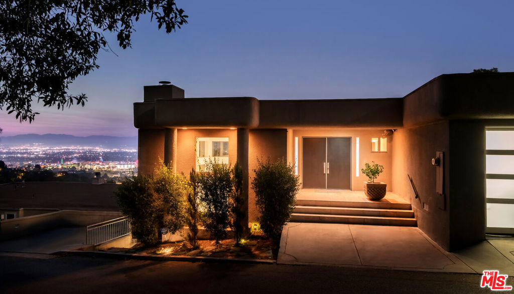 This stunning contemporary home offers staggering panoramic views overlooking Universal Studios and city lights. The kitchen is enormous and opens to a private deck for barbecuing and luxurious outdoor dining area. The magnificent living room has cathedral ceilings with beautifully designed floor to ceiling windows, accentuated with a separate bar area, fireplace and opens to a large deck to enjoy outdoor living. The master bedroom features stunning views, fireplace, balcony, and spa-like bathroom amenities with a large walk-in closet. Walking distance to the coveted Runyon Canyon. Minutes to the heart of Hollywood, the studios and the Sunset Strip. Many upgrades. The best deal in the Hollywood Hills, priced to sell fast!