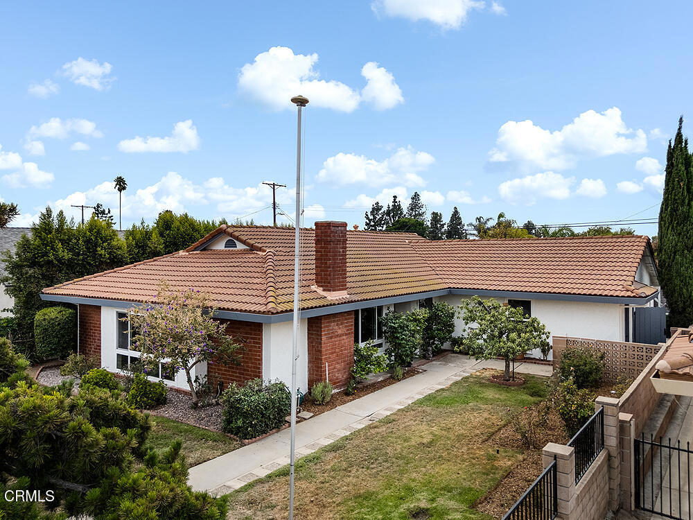 Atop a grand hill sits this California Ranch treasure. From the front yard one can view the San Gabriel Mountains in the distance. There's no one across the street either, part of the gigantic Sepulveda VA Medical Center campus. The front door enters into a parquet floor entryway with a spacious open living room/dining room to the left. The living room has an attractive white brick, wood/gas fireplace with mantel. There's plenty of natural light from two extra large picture windows with plantation shutters. Off the dining room is an updated kitchen with large tile linoleum flooring, granite countertops, a Kohler double porcelain sink with nickel gooseneck faucet, custom built wood cabinets with chrome hardware, soft close drawers and a pantry closet, recessed lights, a Dacor 5-burner stovetop with hood vent, a Maytag double oven, and a 2024 Frigidaire Gallery stainless steel refrigerator and freezer. Off the kitchen is a laundry room with Maytag gas dryer and LG washing machine, a broom closet and a door accessing the side of the house. There are three bedrooms including a primary suite with laminate flooring, large closet with mirror sliding doors, ceiling fan and light and sliding glass doors to the backyard. The updated bathroom includes a granite counter vanity and shower with rainfall shower system and handheld wand, and wood-like tile floor. The other two bedrooms are good-sized including the closets. There is a hallway bathroom also updated with granite counter vanity, seamless glass shower with rainfall shower system and handheld wand, and wood-like tile floor. Off the third bedroom is a 330 sq ft wood paneled, carpeted bonus room with built-in shelves, recessed lights, and access to the backyard. There's a utility room off this room with a work bench and shelves. The fully fenced front yard is beautifully landscaped with a rose garden, flower bed, a persimmon, Asian pear and white peach trees, and grass. The fully enclosed backyard has two orange trees and another peach tree and grass. There's also a covered cement patio for entertaining. There's a 2-car carport accessed off an alley and two storage sheds. Most of this home's windows have been replaced with vinyl, double pane, UV coated windows. Both the exterior and interior of the home have been just repainted, and there are gutters. Easy access to the 5, 118 and 405, as well as Olivo Shopping Center and CSUN University. This home has it all!