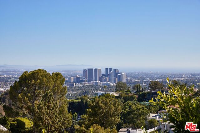 Discover the ultimate elegance, privacy, and captivating city, ocean, and canyon views in Trousdale Estates' contemporary masterpiece located on one of the most desirable streets in Beverly Hills. Behind a well-landscaped, oversized motor court in a lush & hedged setting is a glass-walled oasis drenched with natural light and unobstructed views, reinvented by SOHO House designer Trip Haenisch. It features a sensational great room with super high ceilings and an open, flowing plan. A spacious living room, family room, bar, gourmet kitchen, and dining room seamlessly adjoin, with a soaring double-sided fireplace as its stunning visual anchor. Floor-to-ceiling glass doors open to spectacular outdoor entertaining spaces with an expansive pool, raised spa, lounge, alfresco dining areas, and a private garden for two reaching the skyline. The finest finishes throughout, such as French oak, limestone floors, Calcutta countertops, and Terrazzo stone, further enhance its enchanting appeal. Each of its four large bedroom suites has its patio. The exquisite primary suite features an airy, spa-like bathroom with a shower and tub under the skylight, overlooking the vistas. Live among the most discerning elite in this one-of-a-kind hillside sanctuary in one of the most coveted neighborhoods in Beverly Hills.