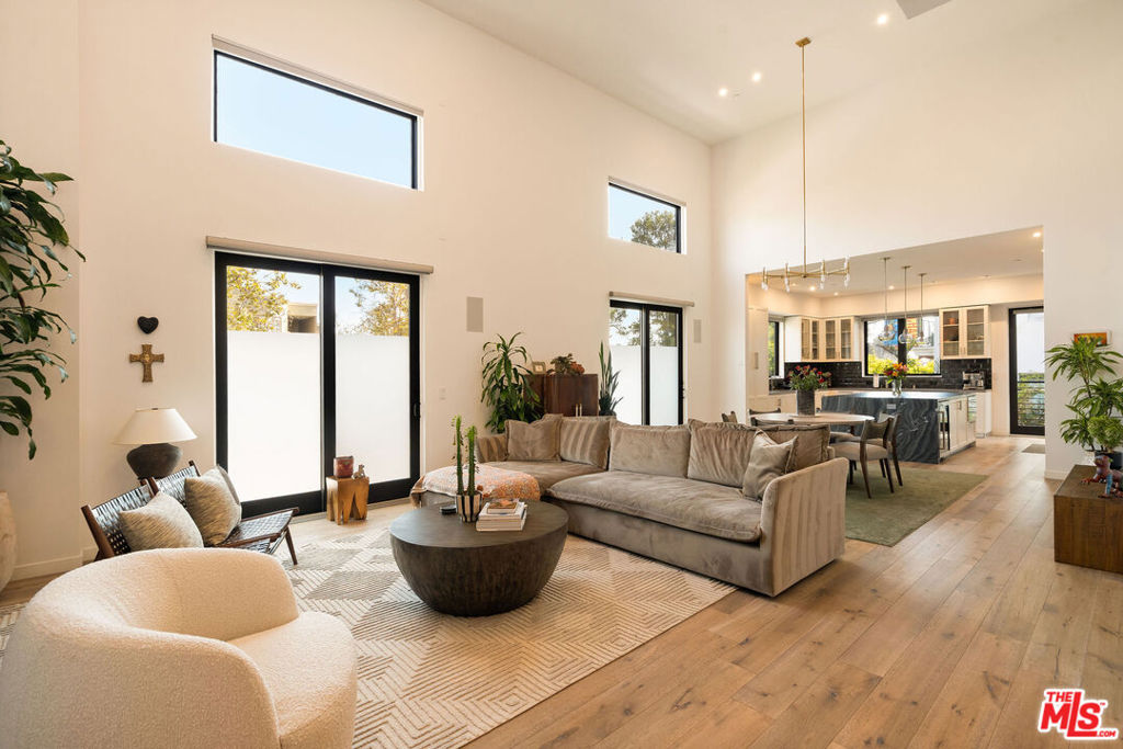 Perched on the border of Century City and Beverly Hills, this penthouse suite is a refined statement in modern elegance. One of only four residences in a boutique 2019-built building, the home offers privacy, style, and seamless indoor-outdoor living in one of LA's most coveted neighborhoods. Direct elevator access, programmed with private control, opens into a sun-drenched open layout, where soaring ceilings, wide-plank white oak floors, and clean architectural lines set the tone for a sophisticated lifestyle. Anchoring the main living space is a stunning chef's kitchen, fully outfitted with Sub Zero and Wolf appliances, extensive cabinetry, and a dramatic waterfall island that doubles as a conversation centerpiece. The living and dining areas unfold beneath double-height ceilings, wrapped in soft natural light and perfectly designed for both intimate evenings and effortless entertaining. Three ensuite bedrooms offer hotel-level comfort, each with custom built-in closets and serene designer bathrooms. The primary suite is a sanctuary of calm with spa-inspired finishes and elevated details throughout. Upstairs, the private mezzanine level leads to a spectacular rooftop deck, accessible directly from inside the unit. Framed by a custom privacy fence and pergola, this open-air oasis invites you to dine, lounge, and entertain while soaking up sweeping city views under the stars. Additional highlights include secure gated parking, a sleek in-building fitness center, and solar energy integration. With its modern amenities and thoughtful design, the residence balances calm luxury with vibrant city living. All of Beverly Hills and Century City are at your doorstep: stroll to the Westfield Century City Mall, world-class dining and shops, Hillcrest Country Club, Roxbury Park, and more. This penthouse is an invitation to live beautifully at the very top of it all.