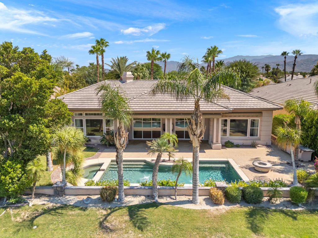 Located behind the guard gates of Mira Vista at Mission Hills this 3,763sf home offers a blend of spacious luxury and relaxed elegance, designed for both comfortable living and effortless entertaining. The thoughtful Santa Rosa floor plan includes 3-bedroom suites, an office and a flexible bonus room that can serve as a media lounge, gym, or even a hobby space. The heart of the home is a generous open concept living area, anchored by expansive windows and glass doors that invite in natural light and frame beautiful views of the backyard and surrounding views of the golf course and mountains. The kitchen is designed for both everyday living and special gatherings, offering ample counter space, rich cabinetry, black appliances, and a seamless connection to the dining and living areas. Step outside and you'll instantly feel the resort-style appeal. The private pool and spa are set against a backdrop of palm trees and blue skies, creating the perfect place to unwind, swim, or soak under the stars. Multiple covered and open seating and dining areas plus BBQ and fire pit make outdoor living a year-round pleasure. Energy efficiency comes built-in with an owned solar system, helping reduce utility costs. The home's location inside Mira Vista means you'll enjoy a secure, beautifully maintained community with easy access to Rancho Mirage's shopping, dining, golf, and entertainment. This isn't just a home, it's a place where style meets comfort, and where the desert's beauty is matched by the warmth and functionality of its living spaces. Whether you're looking for a primary residence or a seasonal retreat, this property offers the space, amenities, and setting to enjoy the very best of desert living.