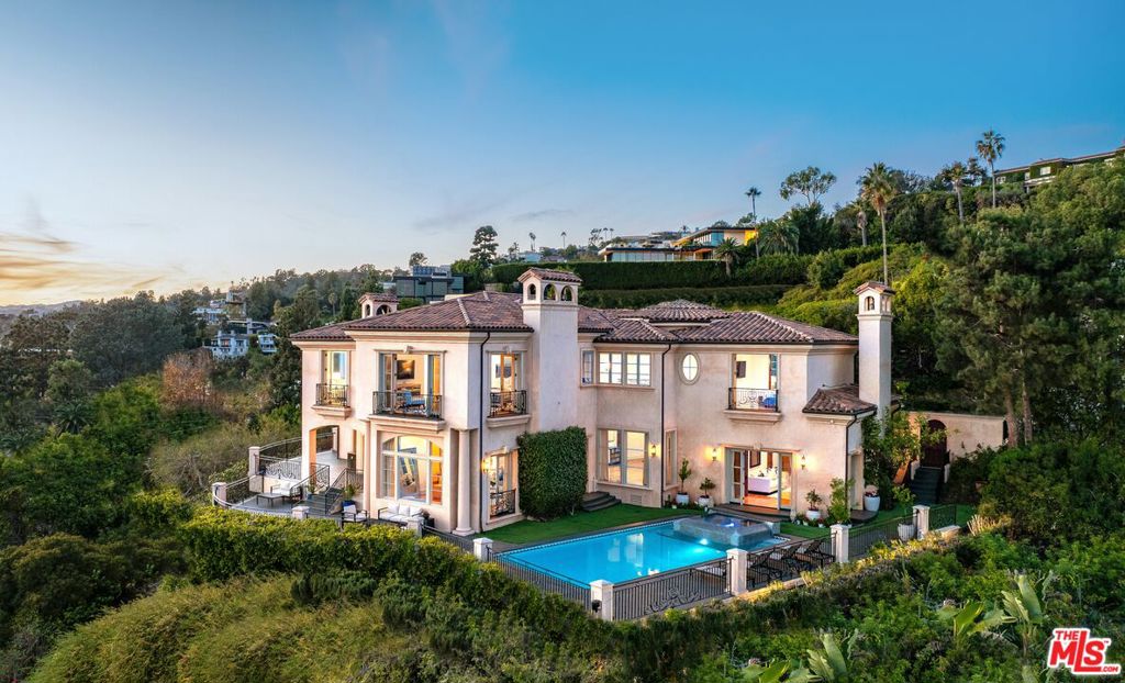 Perched atop a private cul-de-sac promontory above the Sunset Strip, this majestic estate offers castle-like grandeur, exceptional privacy, and panoramic city-to-ocean views.A dramatic flagstone motor court leads to a stately courtyard and 9,400 square feet of timeless Mediterranean design blended with modern sophistication. From the grand foyer featuring 30-foot vaulted ceilings and a sweeping staircase to the spacious living, dining, and family rooms, each space is designed to showcase breathtaking views from Downtown LA to Catalina Island. The gourmet kitchen is a chef's dream, outfitted with granite countertops, Viking appliances, Sub-Zero refrigeration, dual dishwashers, and a walk-in pantry. French doors open to a patio and BBQ area ideal for al fresco dining against the backdrop of Pacific sunsets. Upstairs, the primary suite is a private sanctuary with a sitting room, fireplace, wet bar, three Juliette balconies, and a sprawling terrace with commanding views. Dual spa-style bathrooms feature soaking tubs, steam showers, and custom walk-in closets. Four additional en-suite bedrooms offer luxury accommodations for family and guests. The lower level boasts a media room, custom wine cellar, yoga/dance studio, and a private guest suite with separate entrance. A private elevator connects all levels, and amenities include a three-car garage, ample guest parking, dual laundry rooms, and full smart home integration for effortless living. This is more than a home it's a private retreat designed for grand entertaining and serene living in one of LA's most coveted locations.