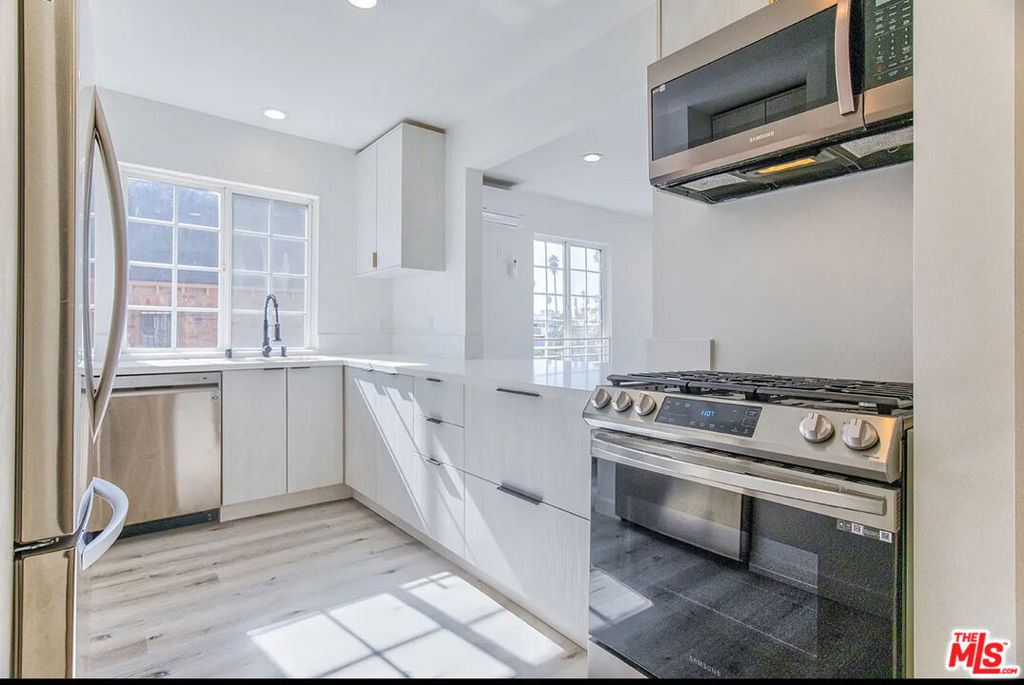 Don't miss this beautifully upgraded Front Building upper unit in a gated 3 units featuring high ceilings, hardwood floors, and a spacious private balcony. Includes two dedicated parking spaces with EV charging outlet. The kitchen offers Samsung stainless steel appliances, refrigerator, dishwasher, microwave, gas range with oven and modern cabinetry. Bathrooms are updated with glass shower enclosures, LED vanity mirrors, and modern toilets. Additional features include in-unit washer and gas dryer, central A/C and heating, gas-operated tankless water heater, built-in bedroom closets, and two private entrances (front and rear). Easy to show and a must-see!