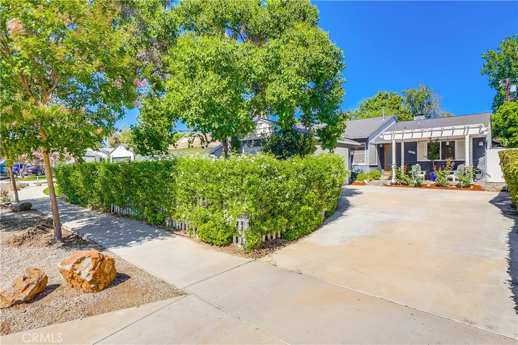 Experience the ultimate in relaxed luxury on one of Valley Village’s most desirable cul-de-sacs. This beautifully designed 3 bed, 3 bath coastal-style cottage offers an open-concept layout perfect for modern living and entertaining. The marble kitchen with butcher block island flows into sun-drenched living spaces anchored by a wood-burning fireplace and custom built-in bookshelves and cabinetry—complete with a new wine and beverage cooler. A thoughtfully designed butler’s pantry/second kitchen adds extra prep space and convenience for hosting. The backyard truly steals the show! Step outside to a private backyard that feels like a boutique Cape Cod resort—complete with a heated pool, outdoor heaters, a pergola for dreamy al fresco dinners, romantic string lights, speaker system, and lush, manicured landscaping. The primary suite is a true sanctuary, offering the feel of a luxury hotel, providing a peaceful escape at the end of the day. Every detail of this home has been thoughtfully curated. This home delivers effortless charm and a lifestyle of comfort, style, and serenity, in one of the area's most sought-after locations. Additional features include copper plumbing, a tankless water heater, new dishwasher, custom Hunter Douglas window coverings, hardwood floors throughout, state of the art Audio/Visual system with Surround Sound, home alarm system (with custom screens) and an attached garage.
