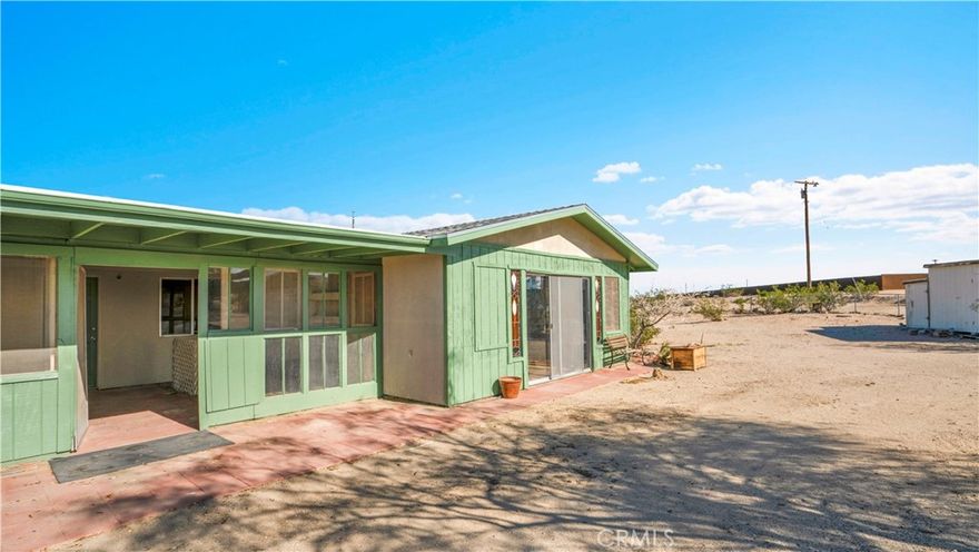 NEW ROOF, NEW EXTERIOR PAINT! Acreage & views! Come see this darling property, perched atop the Sunfair bluff overlooking the moonlight mesa area of north Joshua Tree! See both San Jacinto and San Gorgonio peaks from this location--many mile views! Its rustic and original condition offer a unique style filled with Joshua Tree character--not just another stucco box! On a fenced 2.5 acre lot, this large and roomy 2-bedroom 1-bath home features a living room with fireplace, open kitchen / dining area, a studio (converted garage) with wood stove,  a storage container, carport structure, sheds and more! 15 minutes from downtown Joshua Tree and not much farther to the west entrance of Joshua Tree National Park. Come see today!