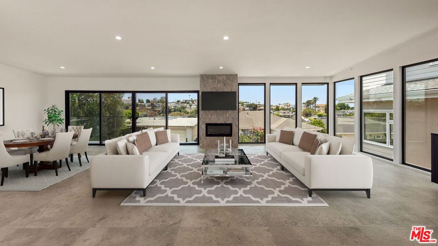 Perched in the heart of Playa del Rey and fully remodeled in 2025, this stunning multi level home offers sweeping views of the Ocean, City, and Marina, with modern amenities and timeless coastal charm. The ground level features a private guest suite or maid's quarters complete with its own washer and dryer, ideal for extended stays or for live in maid. The attached 2 car garage includes two electric vehicle charging stations, combining convenience with sustainability. Up the stairs is where the main entry opens to a bright and spacious living area anchored by a gourmet kitchen outfitted with top of the line Miele appliances, including a built in smart Miele coffee machine. The open concept layout flows into the living room and out onto a balcony where you can relax with ocean views. Two generous guest suites on this floor provide comfortable accommodations for family or visitors, while the private backyard offers the perfect space for entertaining or quiet outdoor living. The top floor is dedicated to the expansive primary suite, featuring a large deep closet, a luxurious spa inspired bathroom, and  views of the ocean. This level also includes two private decks, one overlooking the serene backyard, and the other capturing stunning vistas of the Ocean, City, and Marina, ideal for morning coffee or unwinding at sunset. This beautifully updated Playa del Rey home combines upscale finishes, smart design, and world class views, all just minutes from the beach and local dining.