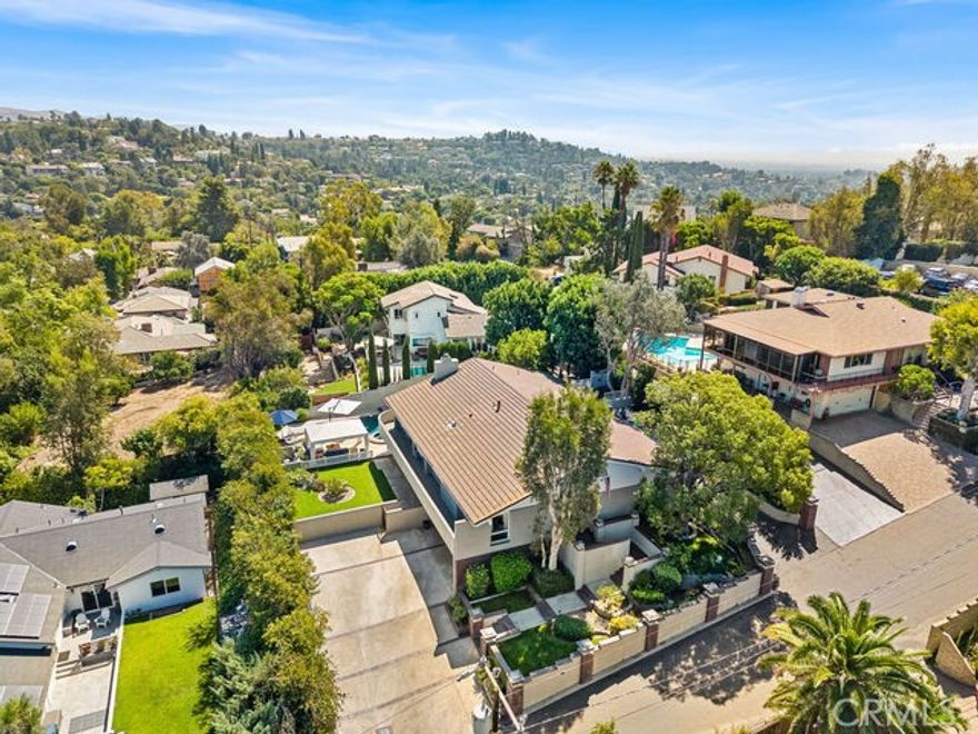 Extensively Renovated View Home Offered at $2,050,000 Welcome to 12782 Periwinkle Drive—a private North Tustin retreat where peaceful mountain views and lush surroundings set the stage for modern living. Thoughtfully updated and meticulously maintained, this residence offers 5 bedrooms, 3.5 baths, with and a versatile bonus room downstairs that could be the 5th bedroom, with private entrance. Spanning approximately 3,400 sq. ft. on a 13,524 sq. ft. lot, the home combines comfort, functionality, and flexibility. Inside, soaring ceilings and rich wood floors elevate the light-filled interiors, while expansive windows frame serene views. The living room just beyond the double-door entry is ideal for entertaining, flowing seamlessly into a formal dining room with built-in buffet. The chef’s kitchen is a showpiece, featuring Sub-Zero and Thermador appliances, a large center island, and a walk-in pantry—all opening to an inviting family room with a fireplace. The primary suite retreat offers a spa-inspired bath complete with a glass enclosed shower and soaking tub, and dual vanities. Outdoors, resort-style living awaits with a Pebble Tec saltwater pool and spa, built-in BBQ kitchen, poolside cabana, wraparound deck, and lush Rogers Gard ens landscaping. The expansive lawn and play area make this the perfect setting for both relaxation and recreation. Additional highlights include an oversized two-car garage with cabinetry and workshop, new dual-zone Carrier HVAC systems, whole-home sound, security cameras, water filtration, an indoor laundry and storage room.  An oversized attached two-car garage and driveway parking for four cars, plus and sideyard R.V access for additional parking. Together, these features create an exceptional blend of privacy, comfort, and resort-style amenities—all in the heart of North Tustin.