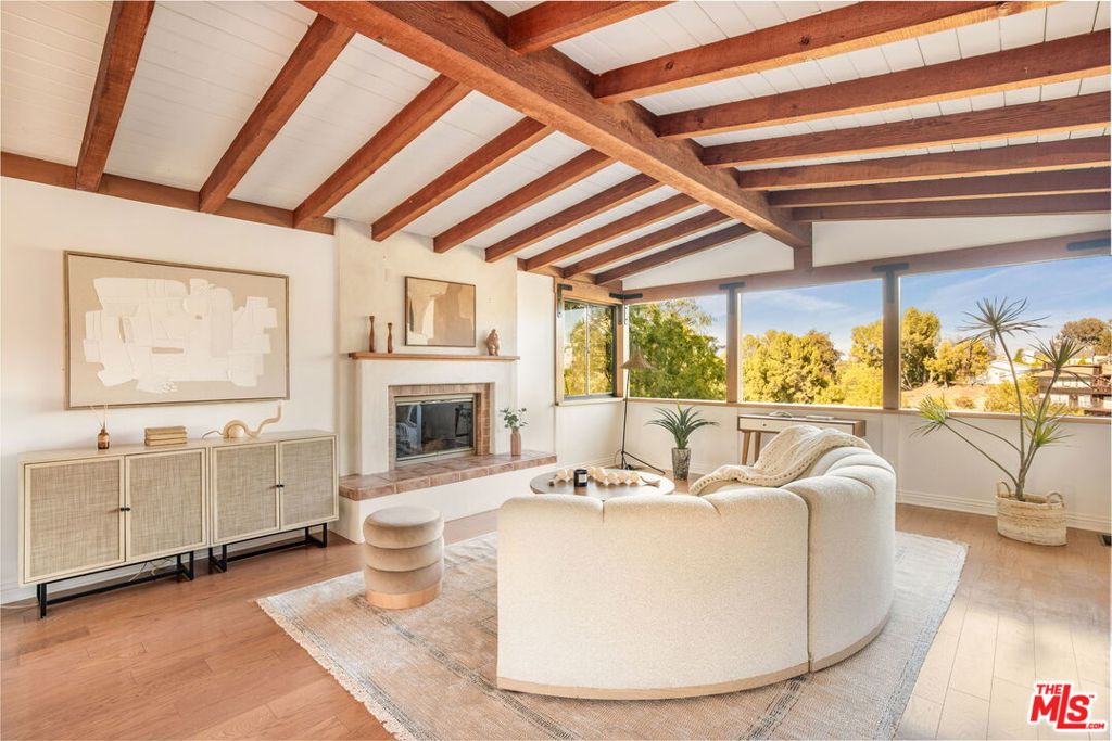 Striking Mid-Century Modern perched above the Boulevard with sweeping views showcases bright interiors with exposed beams and walls of glass. This South of Ventura, 4 bed, 3 bath, 2,875 SF stunner delivers Palm Springs vibes in the heart of the city. With an open floor plan that offers gorgeous sight lines and ease of use connecting, living, dining along with an updated chef's kitchen that features quartzite counters, subway tile, wood cabinets, reverse osmosis drinking system, stainless steel Sub-Zero fridge, and Viking range. This rare gem has vaulted ceilings throughout blending clean lines with warm natural finishes. An oversized primary suite with an updated bathroom. The downstairs can be used as an in-law suite, ADU or large entertainment space. Out front, a gated entry opens to a meticulously curated mature drought-tolerant succulent garden where you can enjoy gorgeous sunsets, setting the tone for the quintessential SoCal lifestyle. This private desert oasis is an elevated sanctuary that brings together design, comfort, and that indoor-outdoor flow perfect for Los Angeles living.
