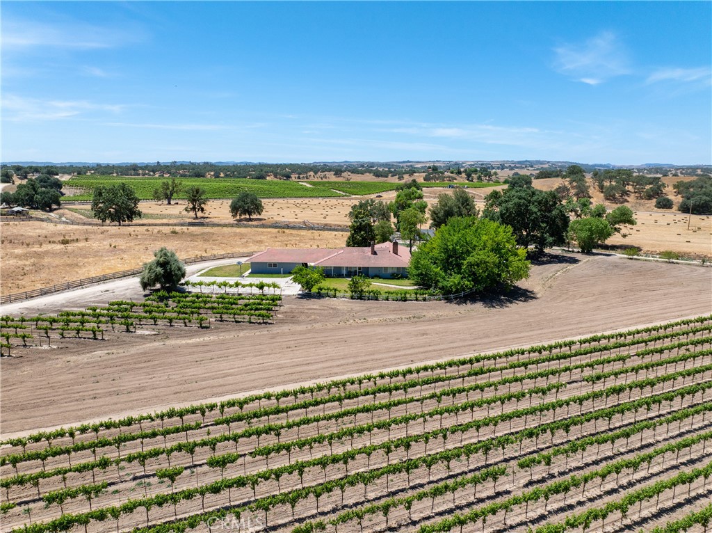A rare opportunity to own 187± acres in the rolling ranchlands east of Paso Robles, this multi-generational property blends vineyard living, agricultural income, and equestrian potential with wide-open opportunity.
Set on scenic terrain spotted with oaks and views and valleys of pastures, the ranch features 107± acres of vineyard (Cabernet, Merlot, Syrah, Zinfandel), including a 40-acre young block under long-term lease, plus 30± acres of hay production and versatile pasture. Water is abundant, from ag and domestic wells supporting both current operations and future expansion.
Three homes totaling 7,262± sq. ft. with 12 bedrooms and 8 baths offer flexibility for extended family, guests, or income-producing rentals. Additional assets range from barns and cattle facilities to panoramic views that reflect the land’s working legacy. Tucked away in the oaks overlooking the land is an additional home building site for those wishing to expand.
Eligible for significant property tax savings under the Williamson Act—this is a rare chance to invest in a productive and inspiring ranch with the acreage, resources, and versatility to grow.