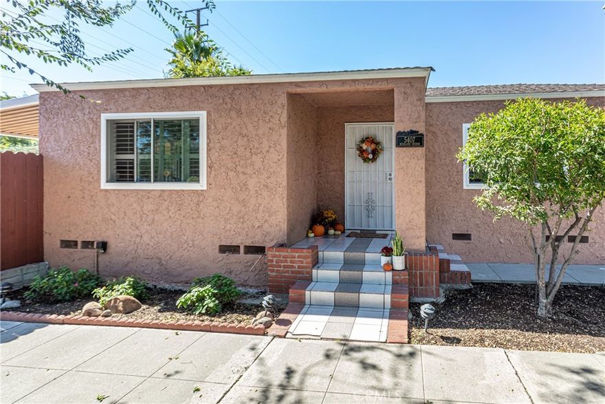 This impeccably maintained 3-bedroom, 1.75-bath home sits proudly on a corner lot across from the scenic Chandler Bike Path, blending comfort, style, and California charm. Step inside to discover rich wood floors, walnut-toned kitchen cabinetry, and stainless-steel appliances including a dishwasher and modern stainless sink all highlighted by natural light and elegant wood shutters on the windows. The spacious layout offers a seamless flow from the living area to the kitchen and outdoor spaces, ideal for first-time buyers or anyone seeking a move-in-ready home with timeless character. Outside, the property shines with thoughtful updates including beautifully stamped concrete with a brick ribbon detail, a covered patio, newer cement and paver work, and a private wooden fence surrounding a tranquil retreat complete with a hot tub and raised garden box. The one-car garage includes a washer and dryer, and the clever lot design enhances the home’s functionality and charm. Additional upgrades include a replaced sewer line to the street, dual-pane windows, fresh paint, mostly copper plumbing, and some electrical updates. Conveniently located near parks, shops, and dining, this home captures the best of North Hollywood living in one delightful package.