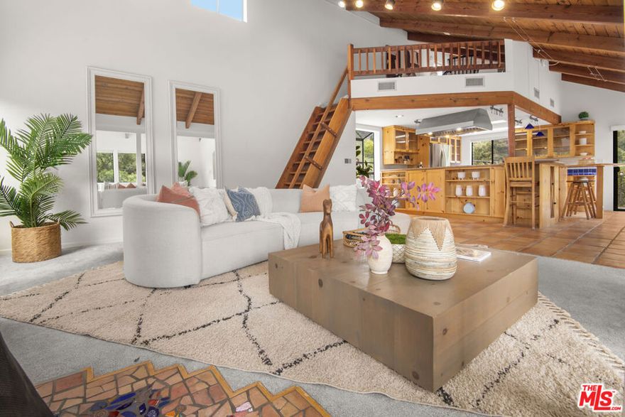 Price Reduction. A flower-filled garden and wide view decks grace this two-bedroom, two-bath canyon home on a large lot. A rose-covered path leads you to the shaded front porch. Open the front door to the cool Saltillo tile entry. First-floor bedrooms and bathrooms rest side by side, each with tall windows and glass doors to let in soft, natural light. Upstairs is the great room, where the living areas have a natural flow for entertaining. Rows of windows frame stunning views over green treetops to Red Rock Park. The high ceiling provides space for a versatile loft area. The generous kitchen features art tile countertops, glass-front cabinets, and lots of storage. Two cute bar-height counters are handy for grabbing a snack. Entertain guests in the dining area or sip tea on the balcony. Grill summer meals on the dining deck that shows off beautiful views of Old Canyon. A huge detached studio sits across the driveway waiting for you to set up your art studio, office, or workout space. A newer roof, solar panels, two Tesla power walls in the carport, and plentiful parking complete the property. Come up to Topanga!